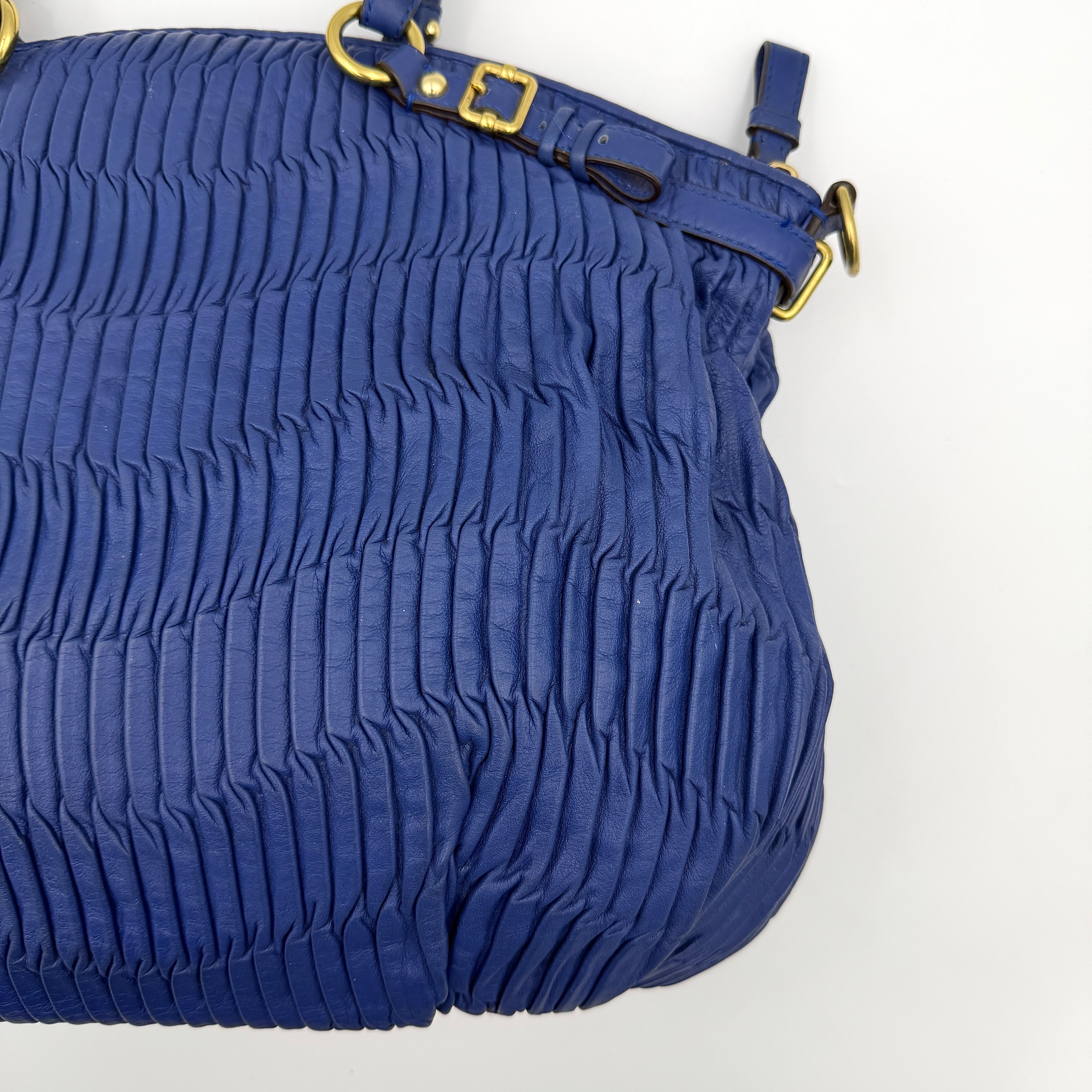 Coach Madison Shoulder Bag in gathered blue leather with gold-tone hardware and removable shoulder strap displayed against a white backdrop.