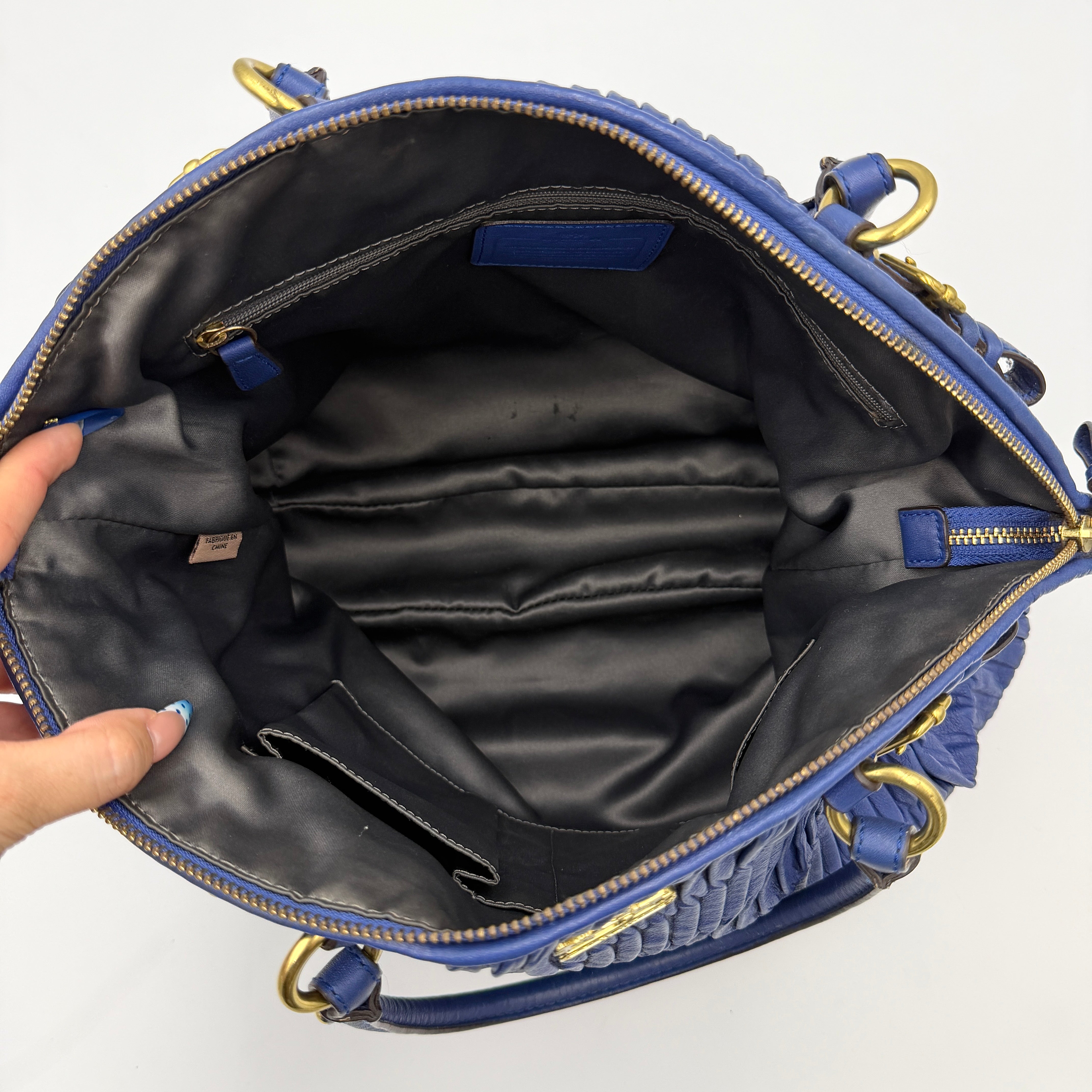 Coach Madison Shoulder Bag in gathered blue leather with gold-tone hardware and removable shoulder strap displayed against a white backdrop.