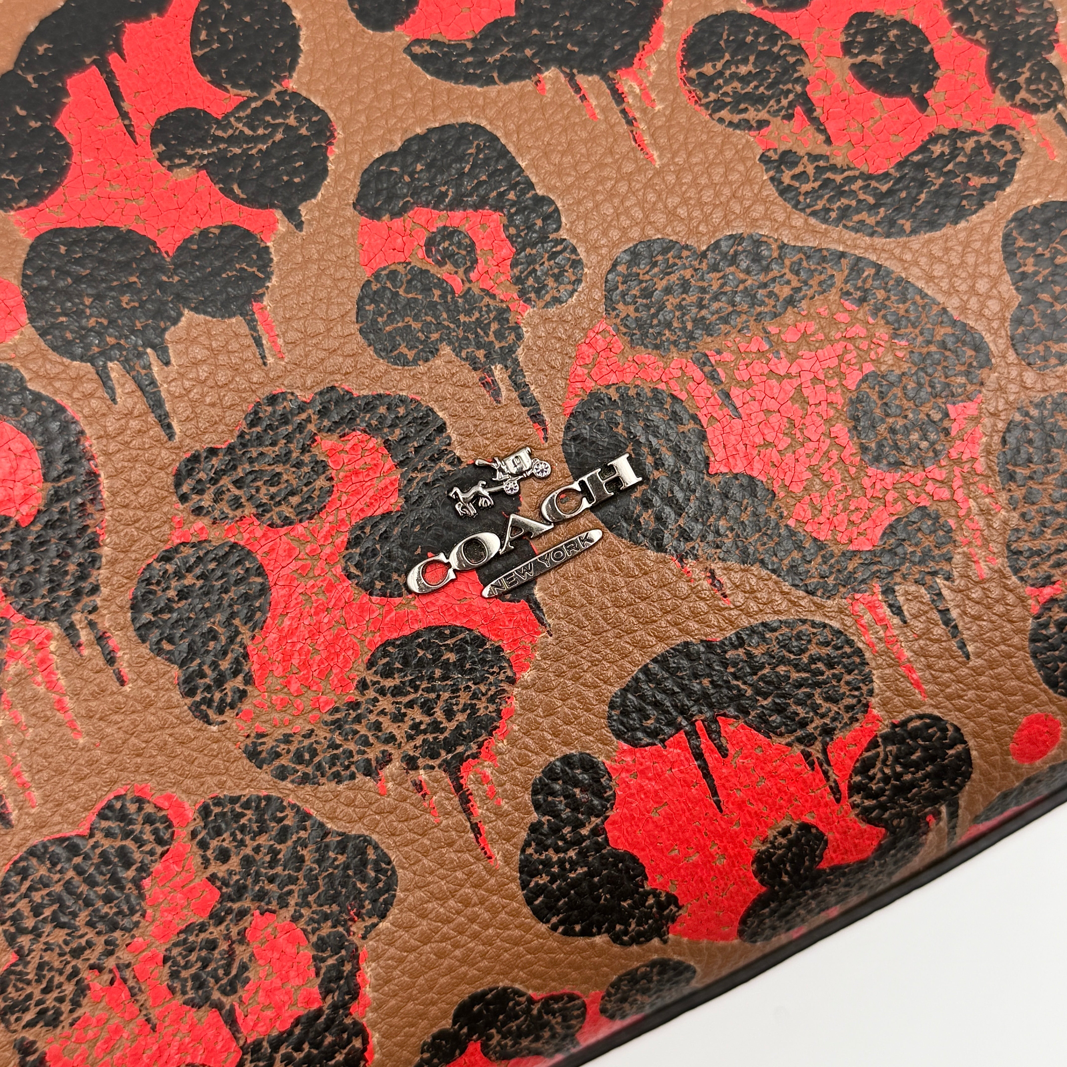Coach City Tote in brown coated canvas, drenched in a vivid red and black leopard print, with black leather handles and silver hardware details.