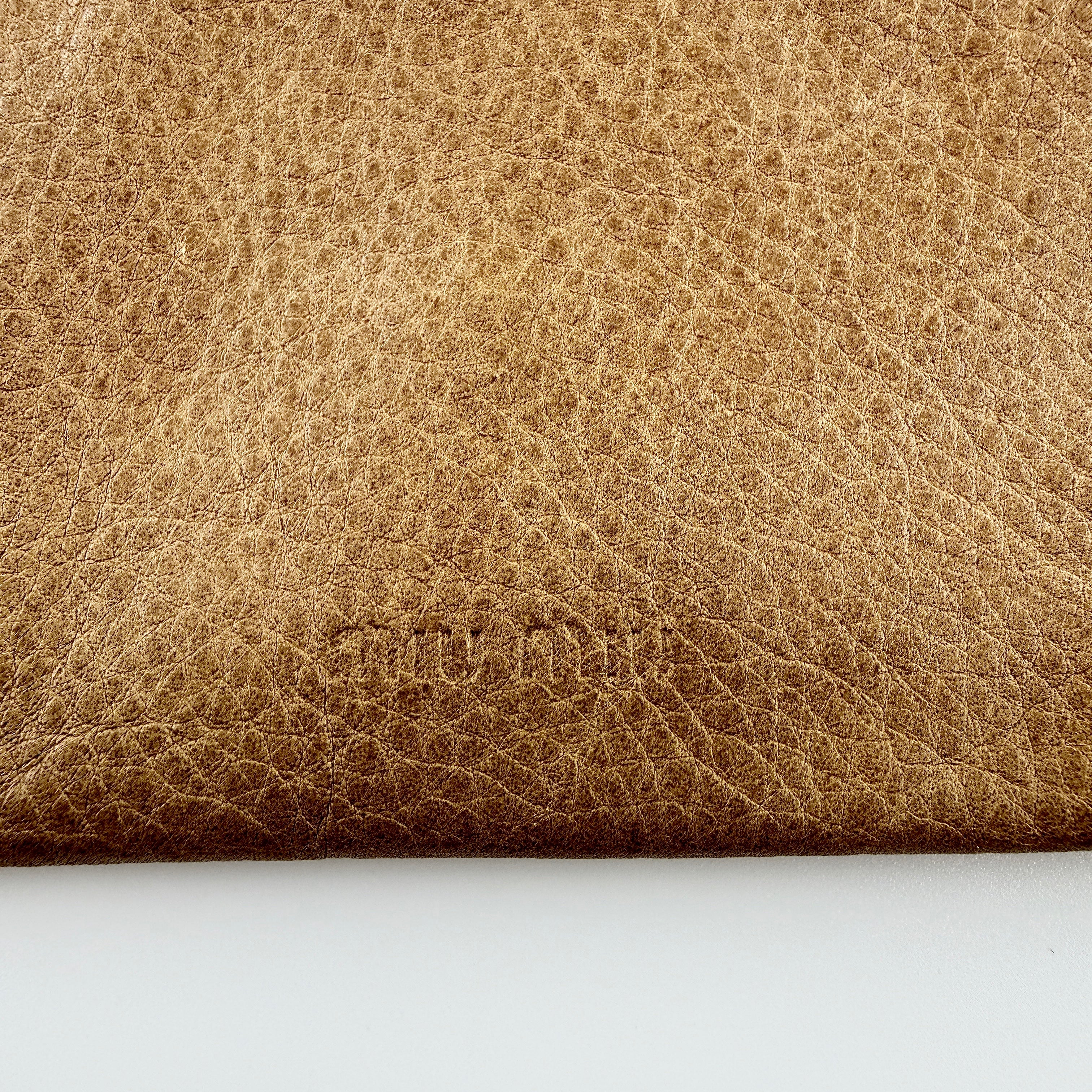 Miu Miu brown textured leather foldover pouch with matte black studs, zip closure, and slim silhouette.