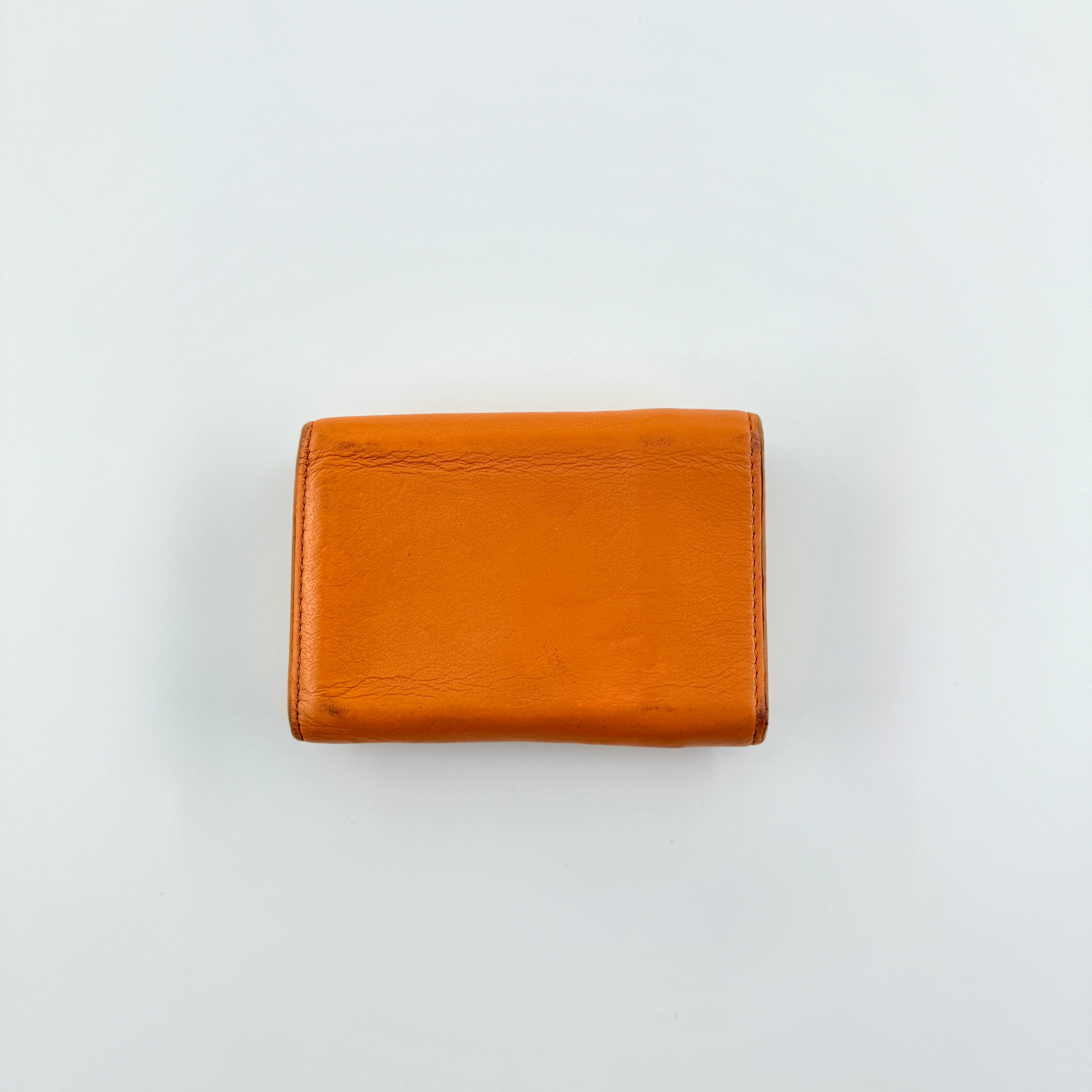 Balenciaga Papier Mini Wallet in vibrant orange grained leather, showcasing its envelope-style flap and silver logo detail.