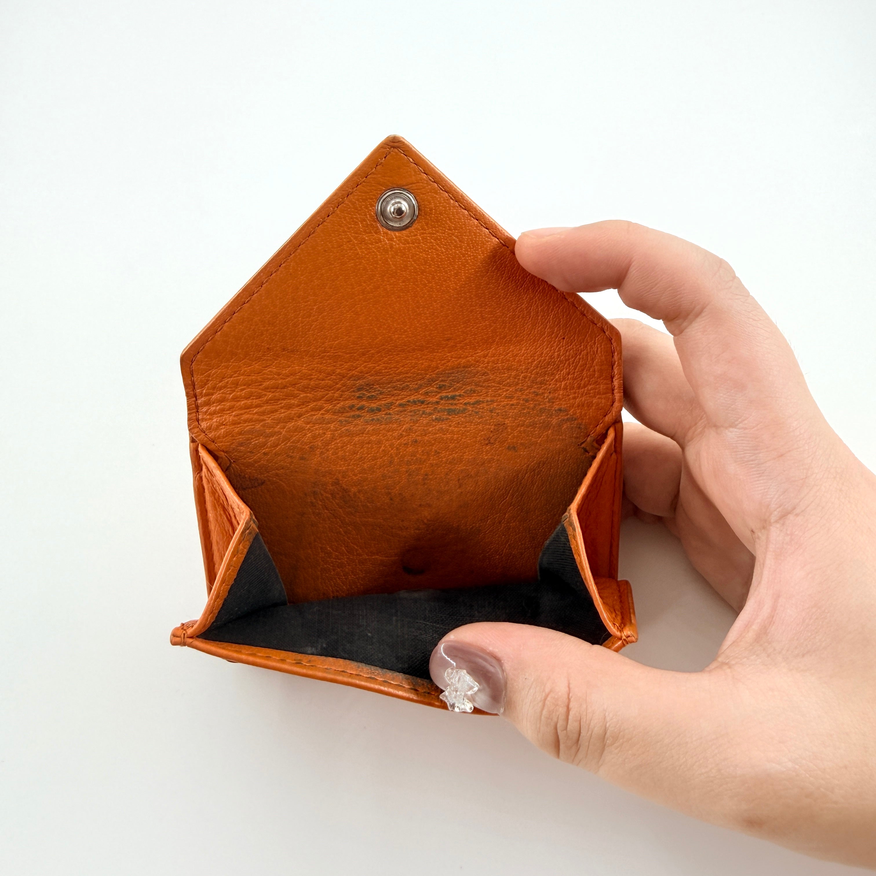 Balenciaga Papier Mini Wallet in vibrant orange grained leather, showcasing its envelope-style flap and silver logo detail.