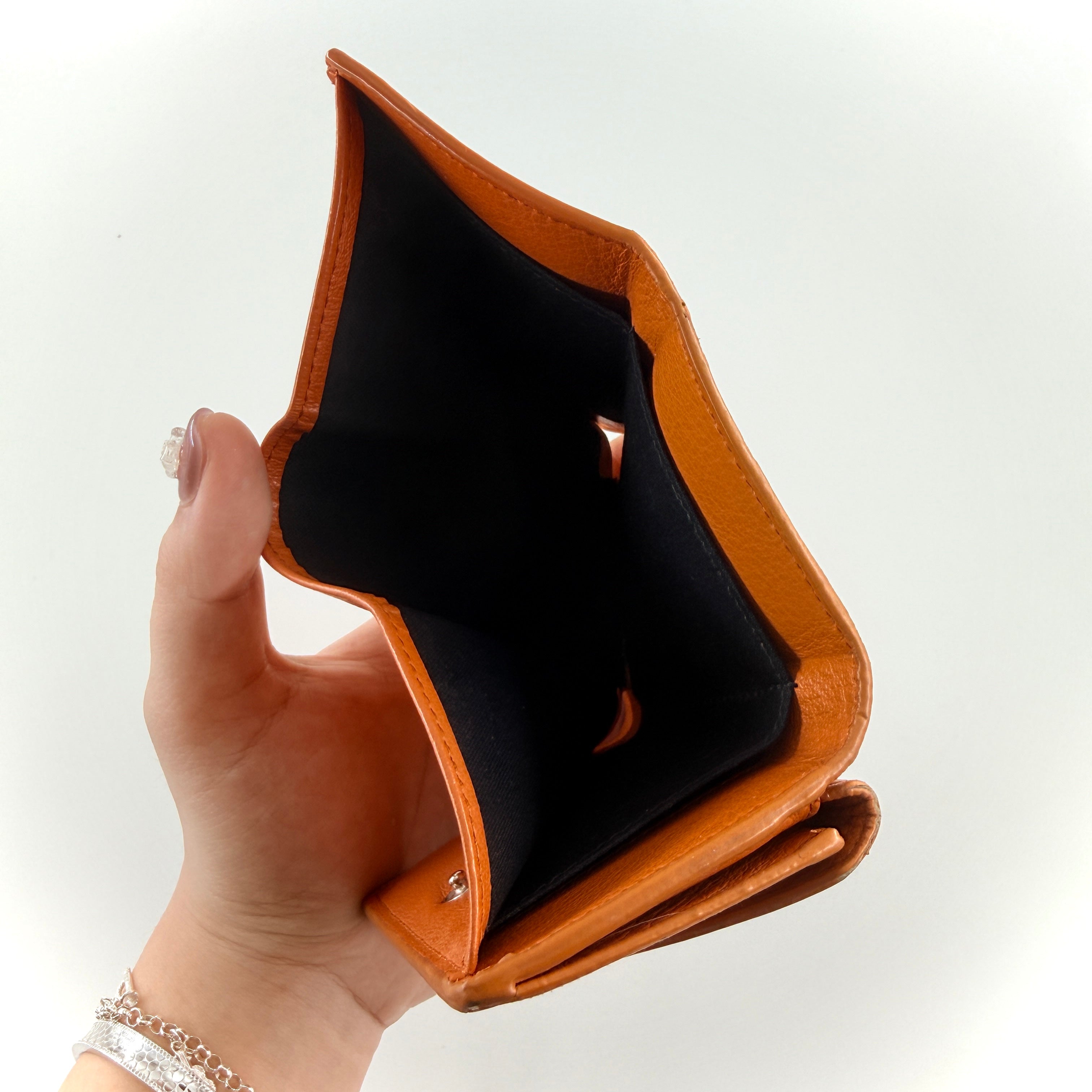 Balenciaga Papier Mini Wallet in vibrant orange grained leather, showcasing its envelope-style flap and silver logo detail.