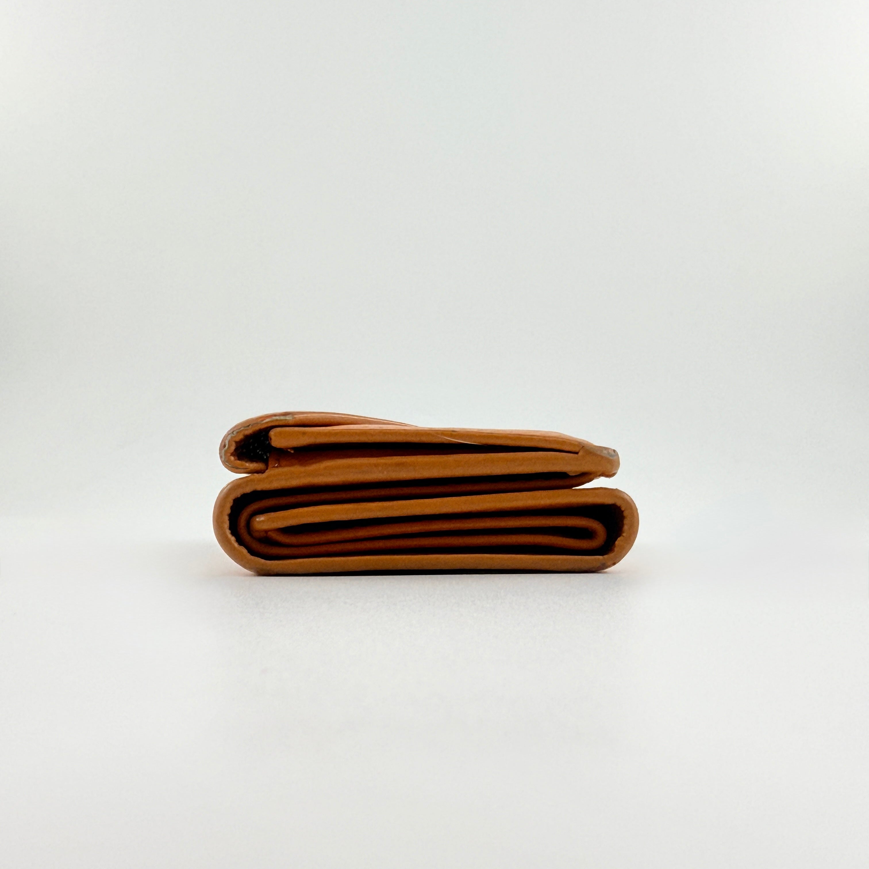 Balenciaga Papier Mini Wallet in vibrant orange grained leather, showcasing its envelope-style flap and silver logo detail.