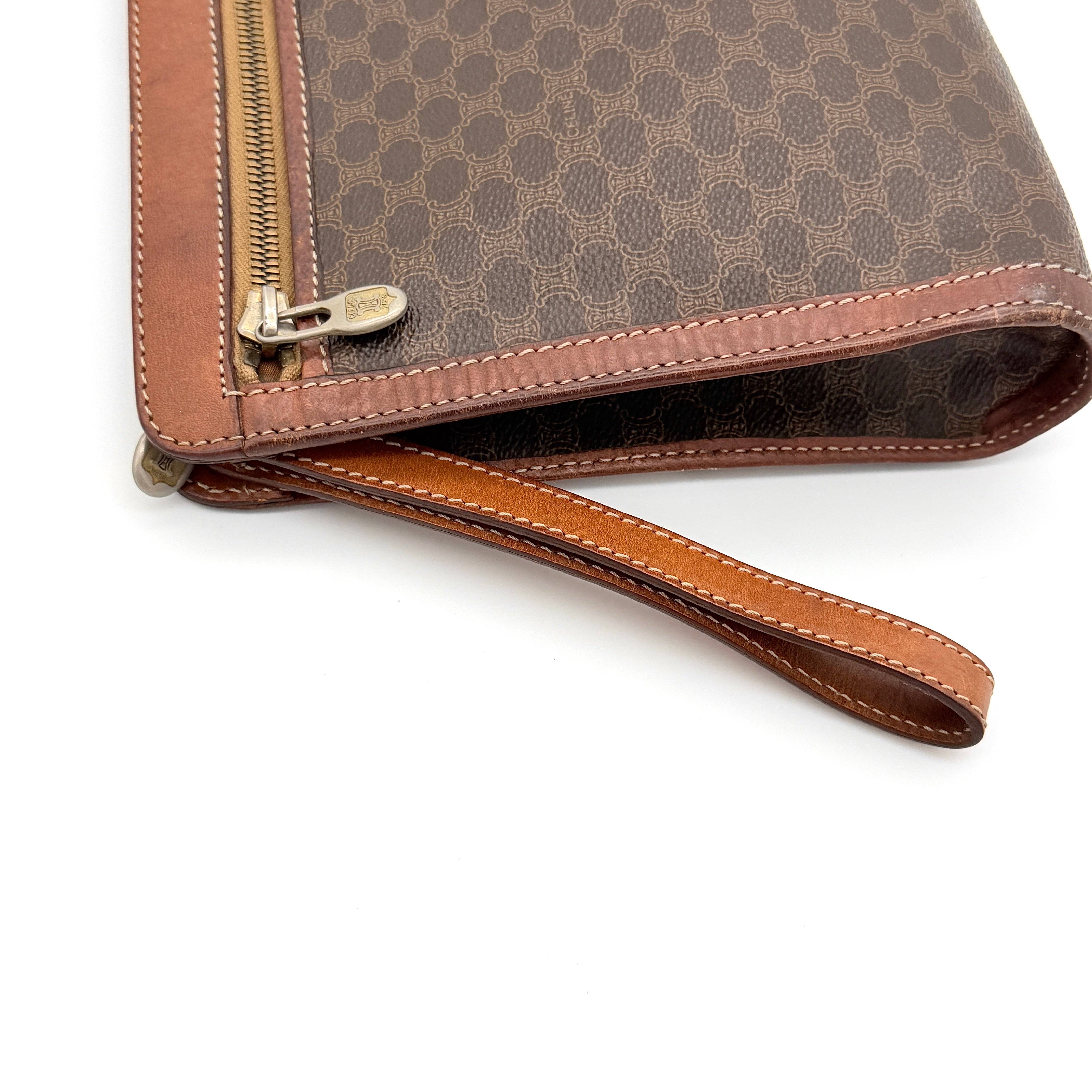 Front view of the Celine Triomphe Macadam clutch bag in brown canvas with tan leather trim and zip pocket.