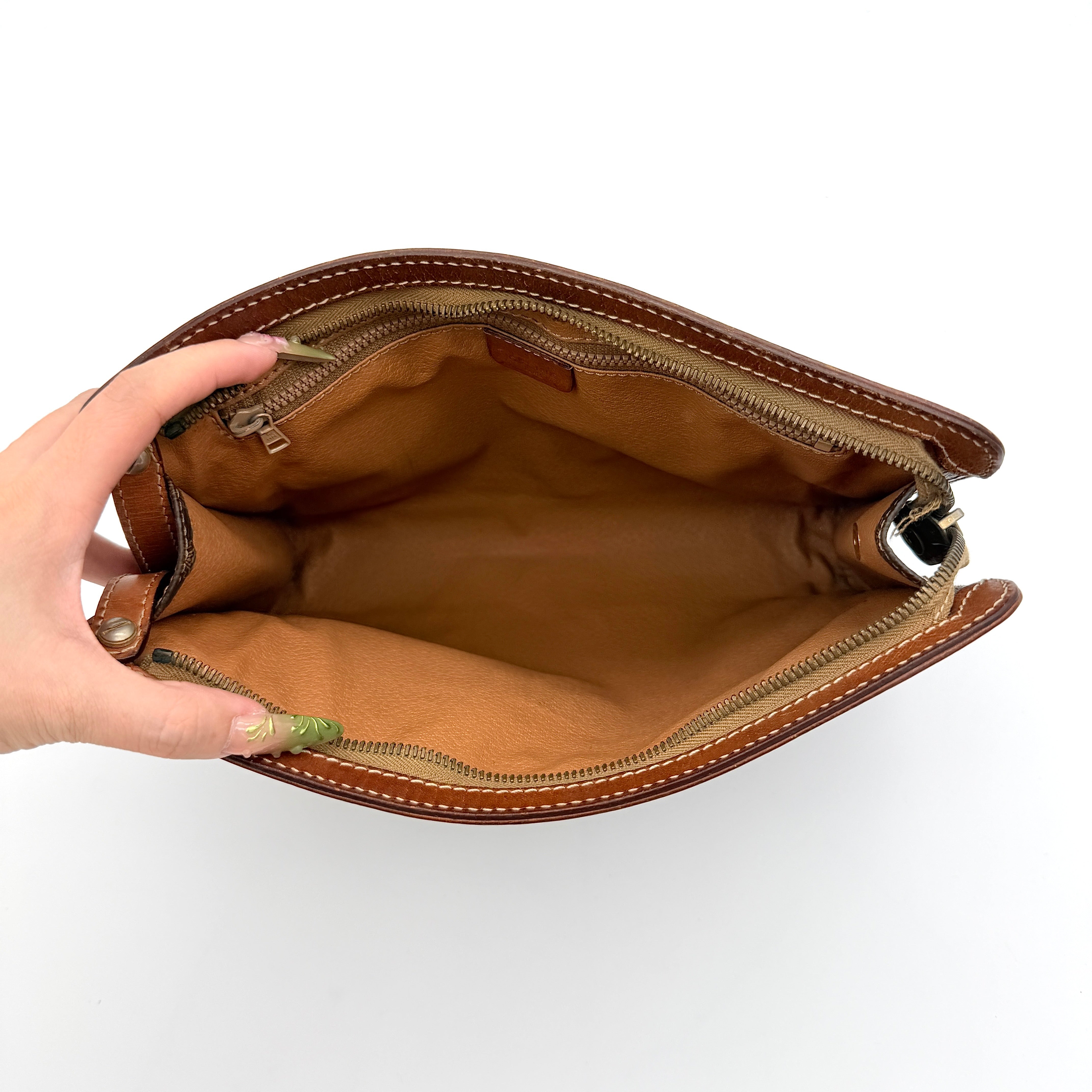 Front view of the Celine Triomphe Macadam clutch bag in brown canvas with tan leather trim and zip pocket.