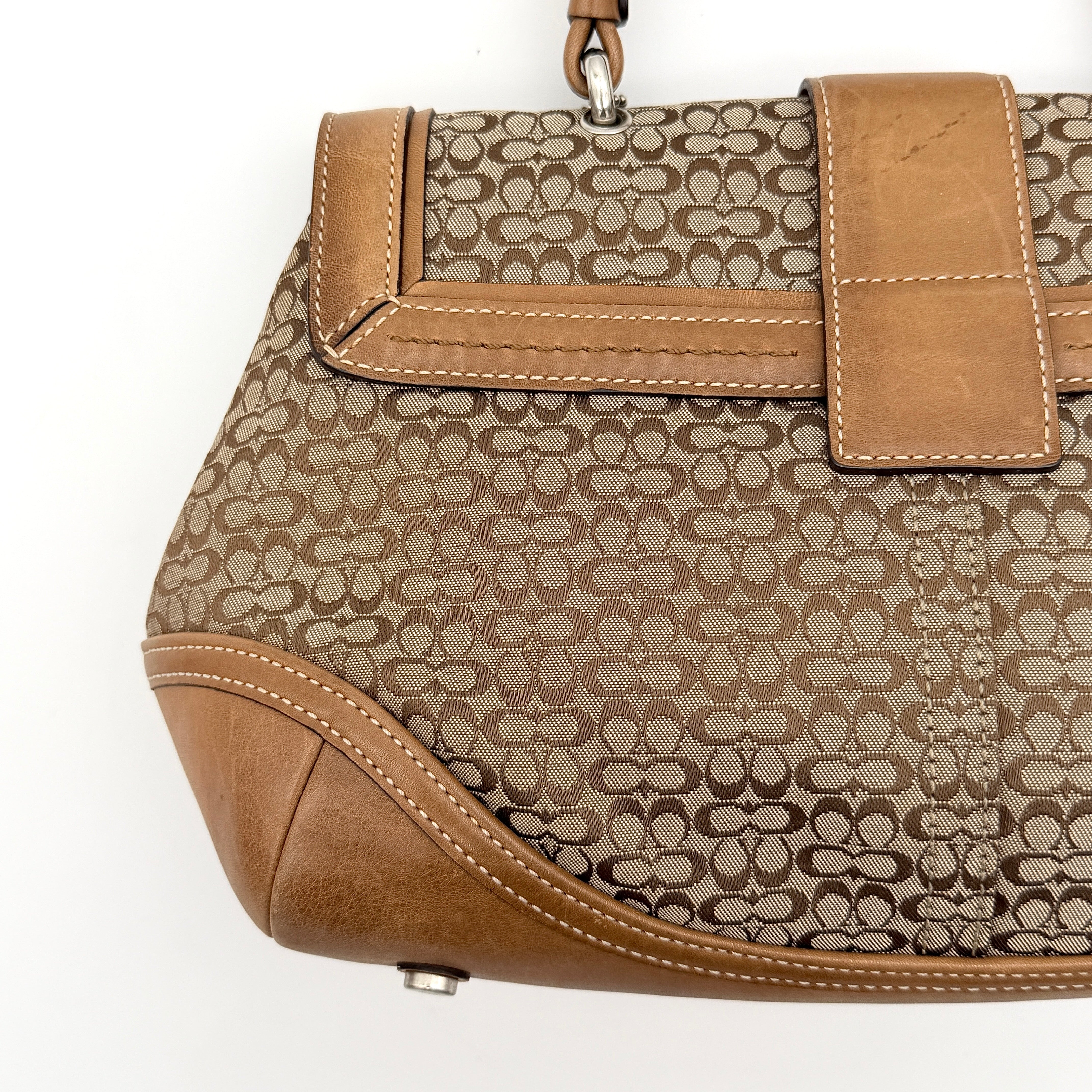 Coach Signature Soho shoulder bag in beige jacquard canvas with tan leather trim and silver buckle, shown against a white background.