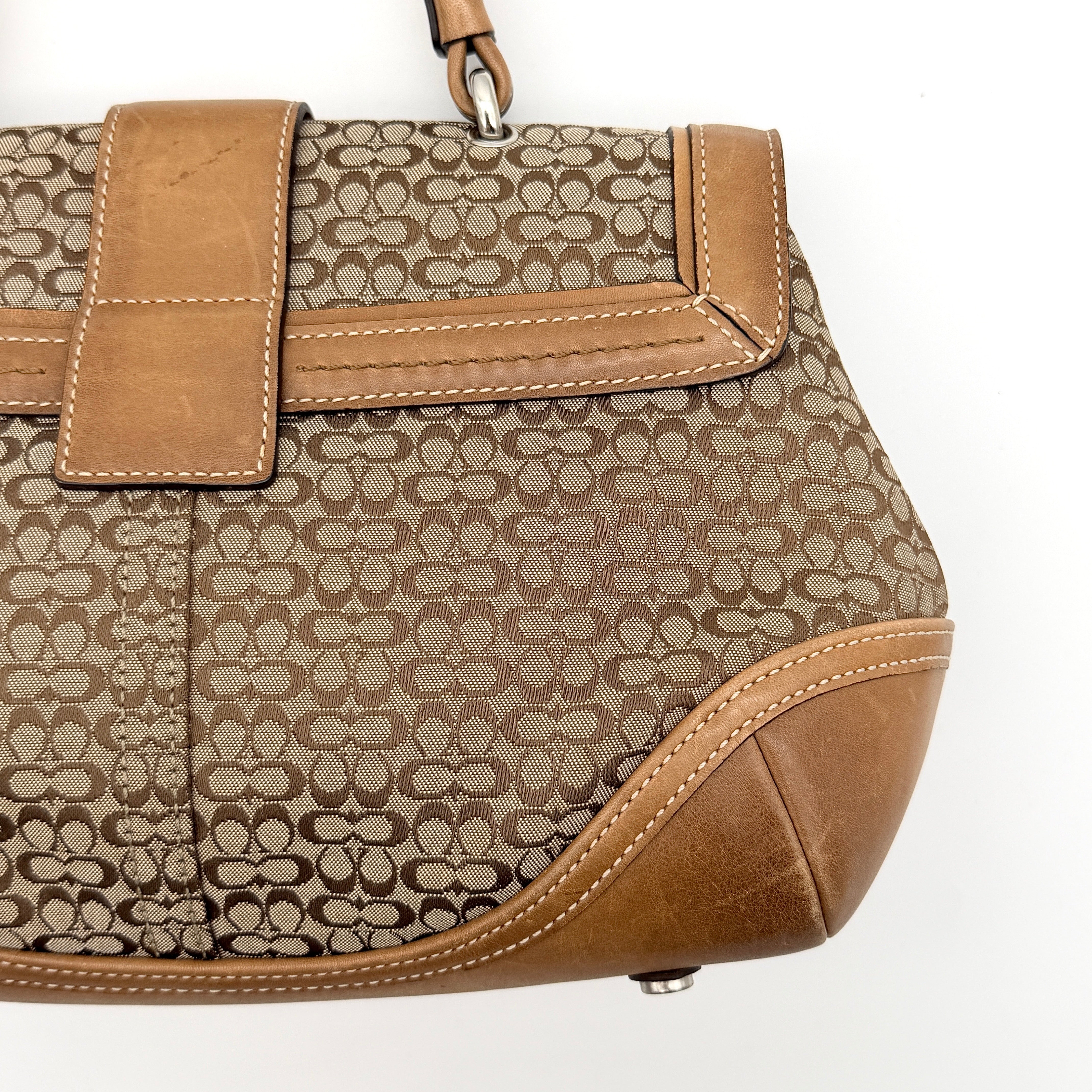 Coach Signature Soho shoulder bag in beige jacquard canvas with tan leather trim and silver buckle, shown against a white background.