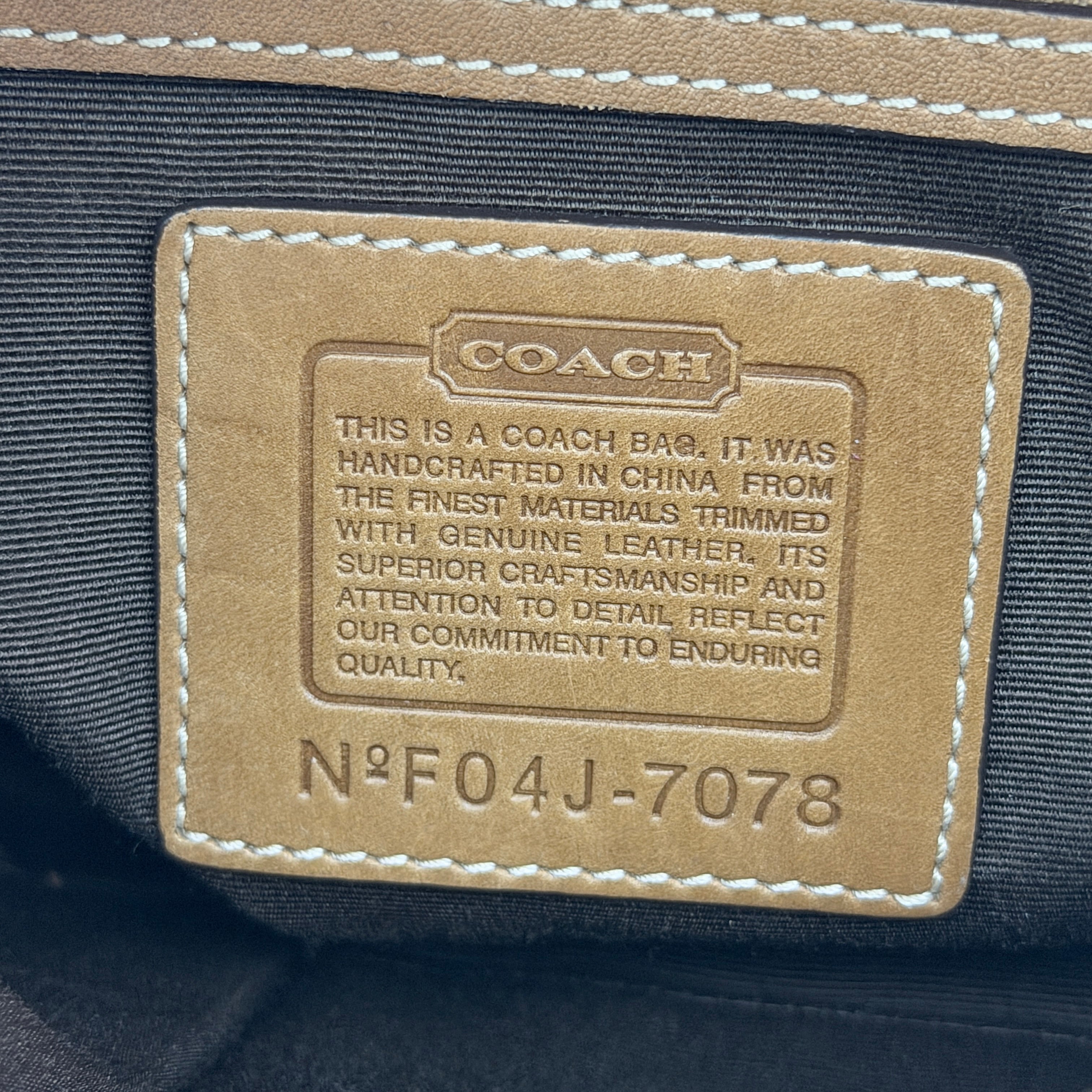 Coach Signature Soho shoulder bag in beige jacquard canvas with tan leather trim and silver buckle, shown against a white background.