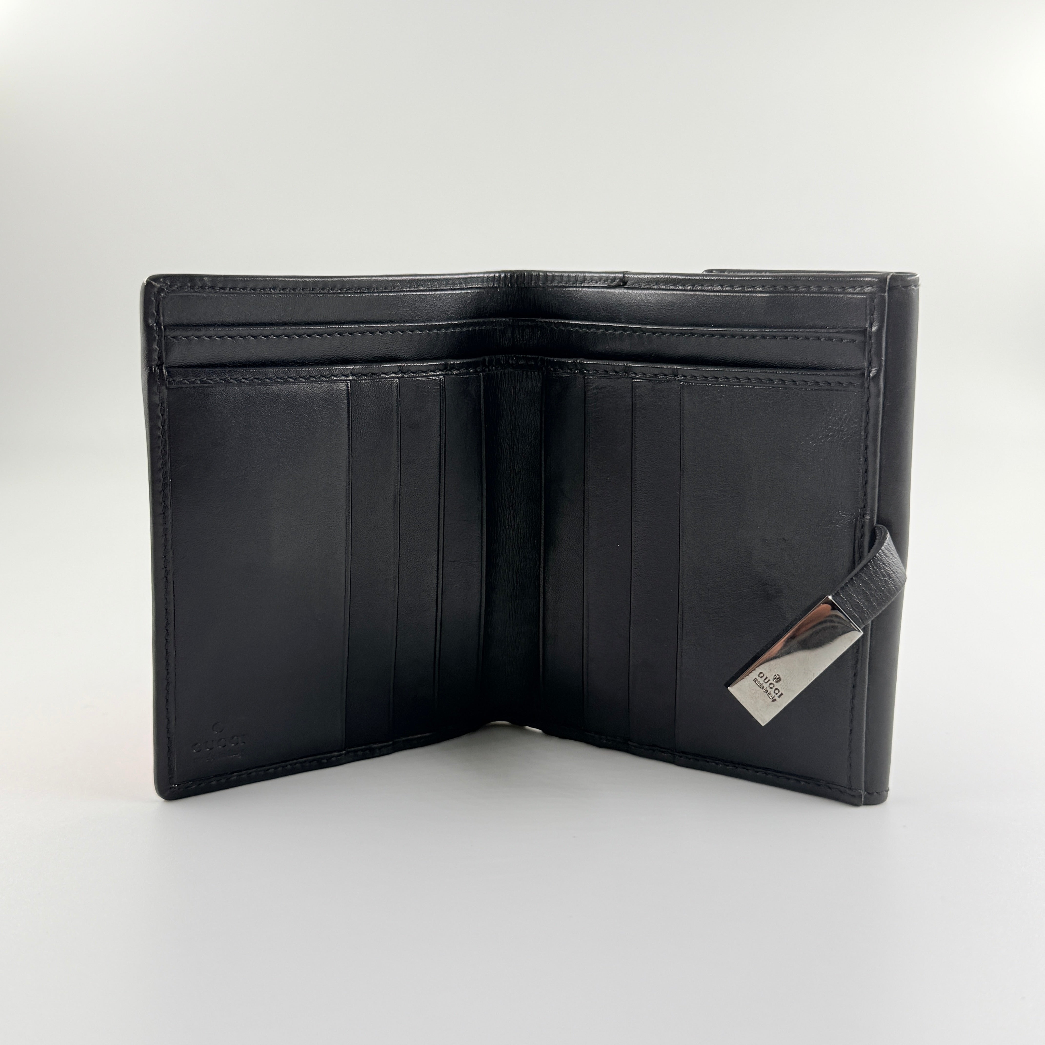 Gucci compact wallet with vibrant pink floral canvas, black leather trim and a silver-tone clasp, front view.
