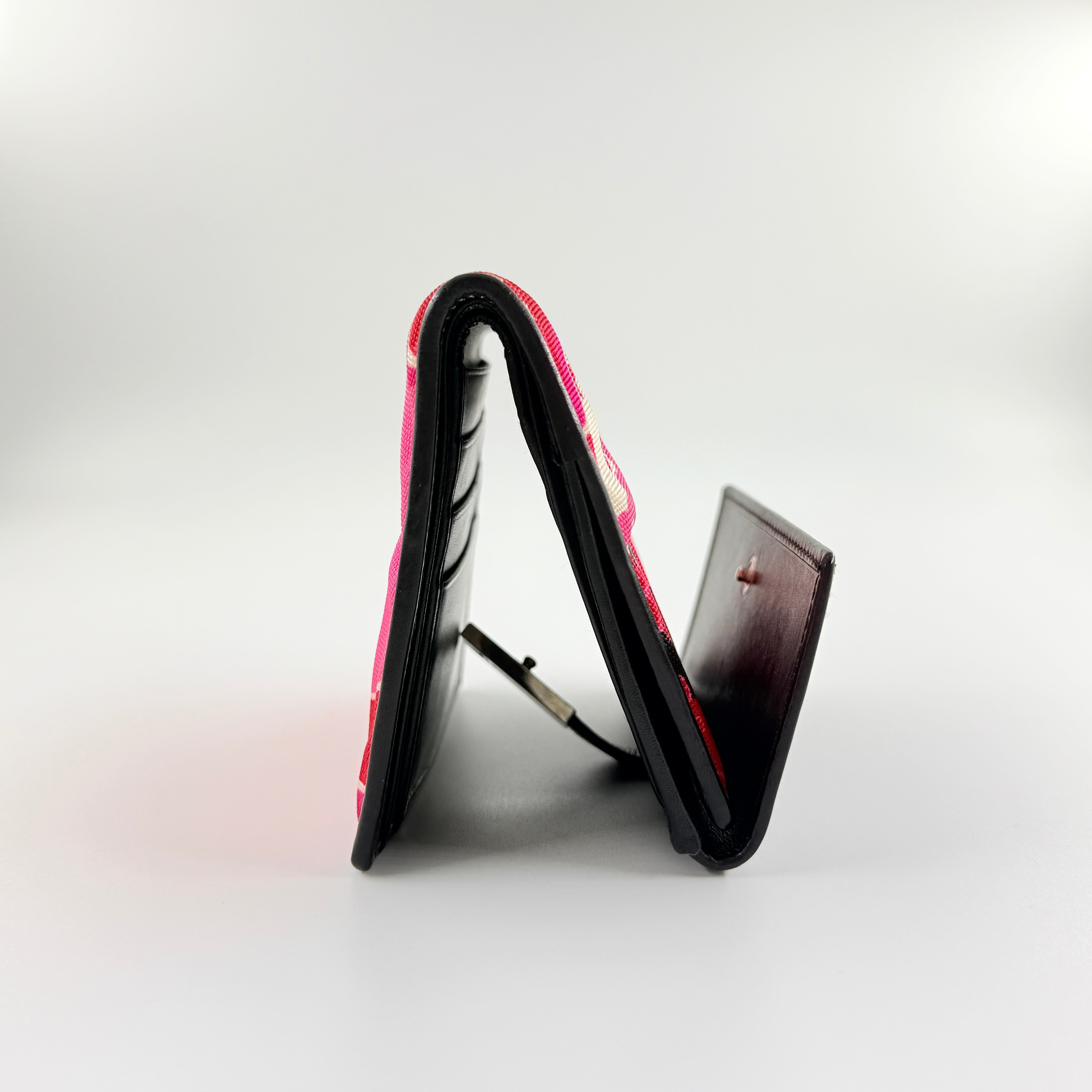 Gucci compact wallet with vibrant pink floral canvas, black leather trim and a silver-tone clasp, front view.