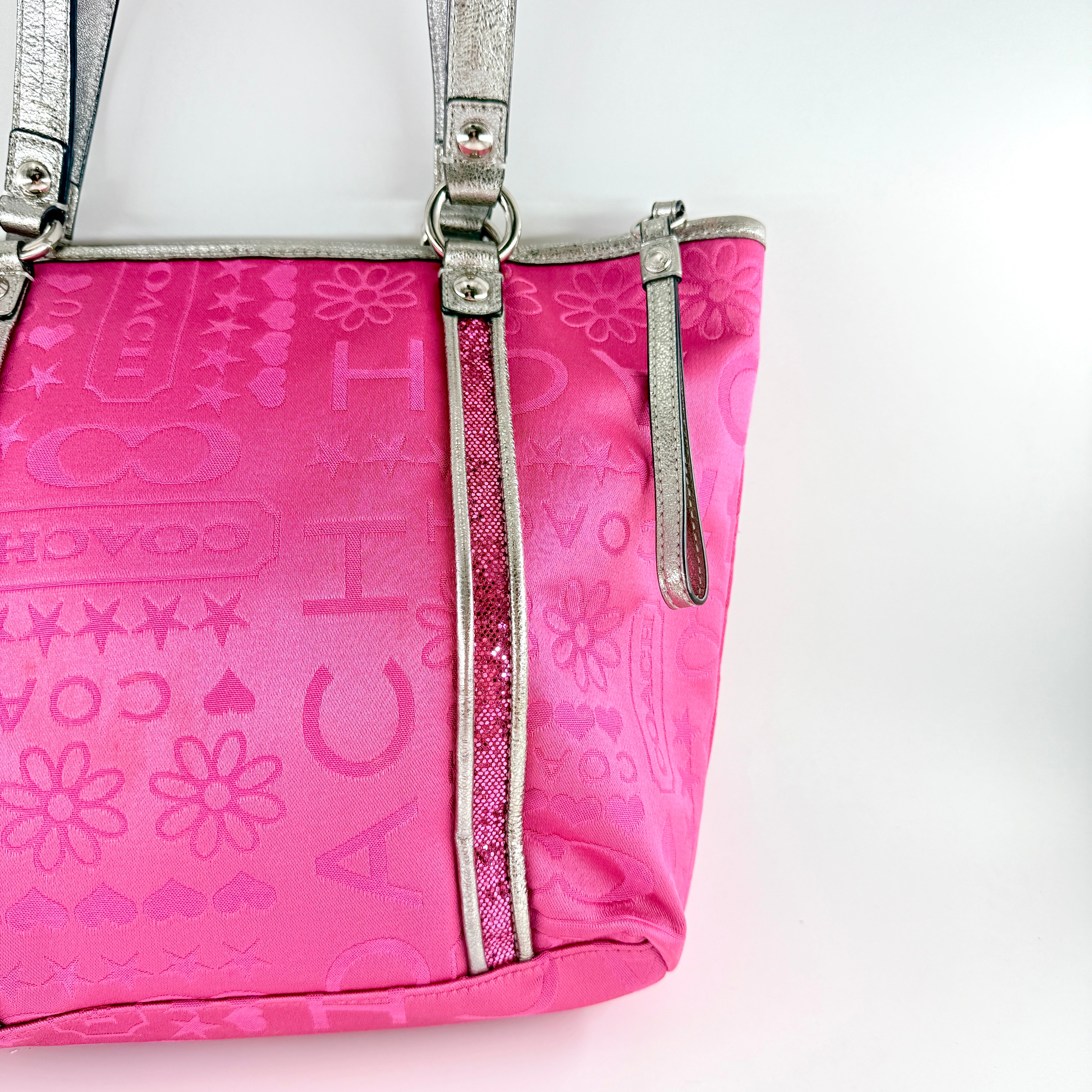 Coach Poppy Bandana Glitter Graffiti Tote Bag in vibrant pink with metallic silver handles, adorned with glitter accents and butterfly charm.