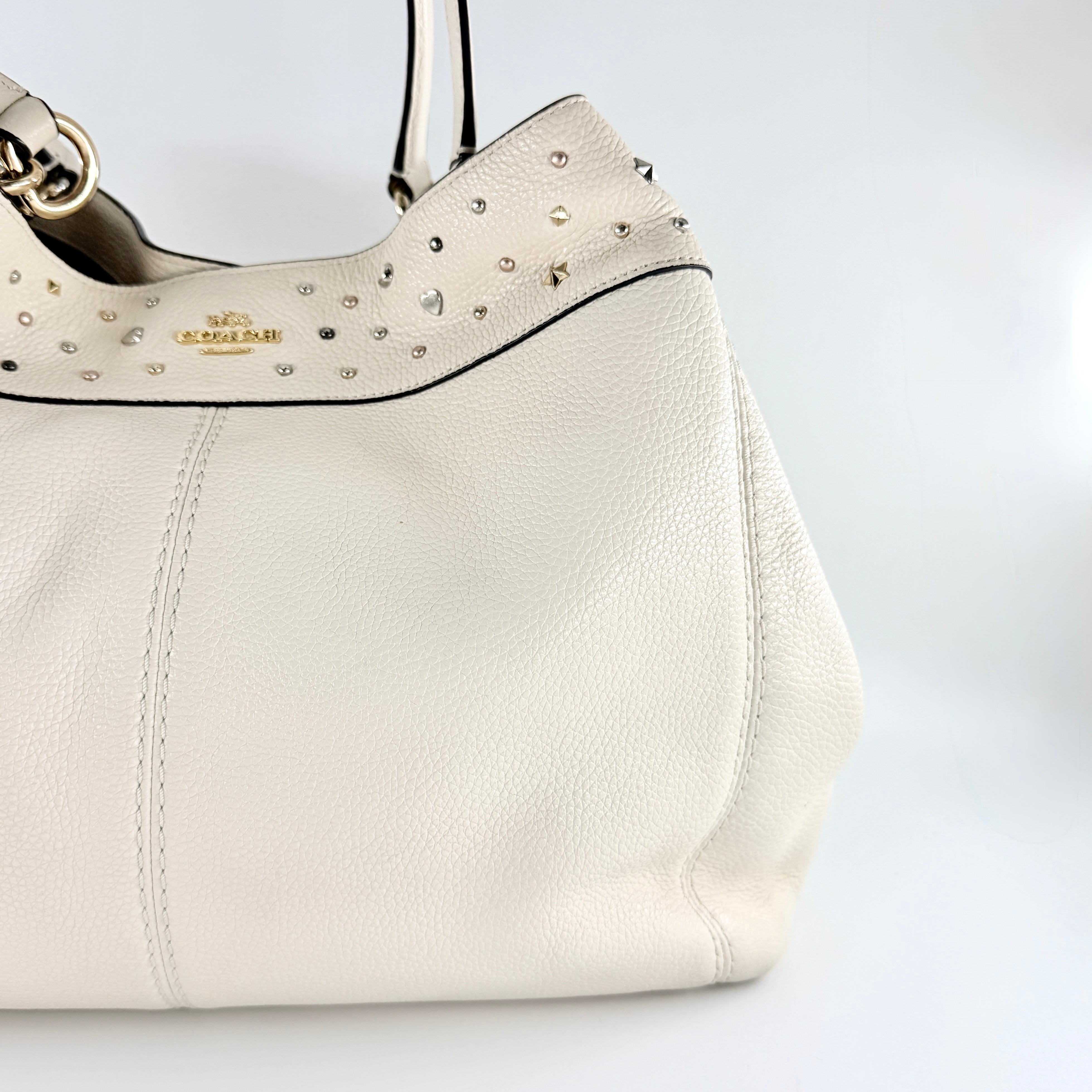 Coach Lexy Stardust Studded Chalk Hobo in ivory pebbled leather, adorned with mixed metal studs and dual handles.