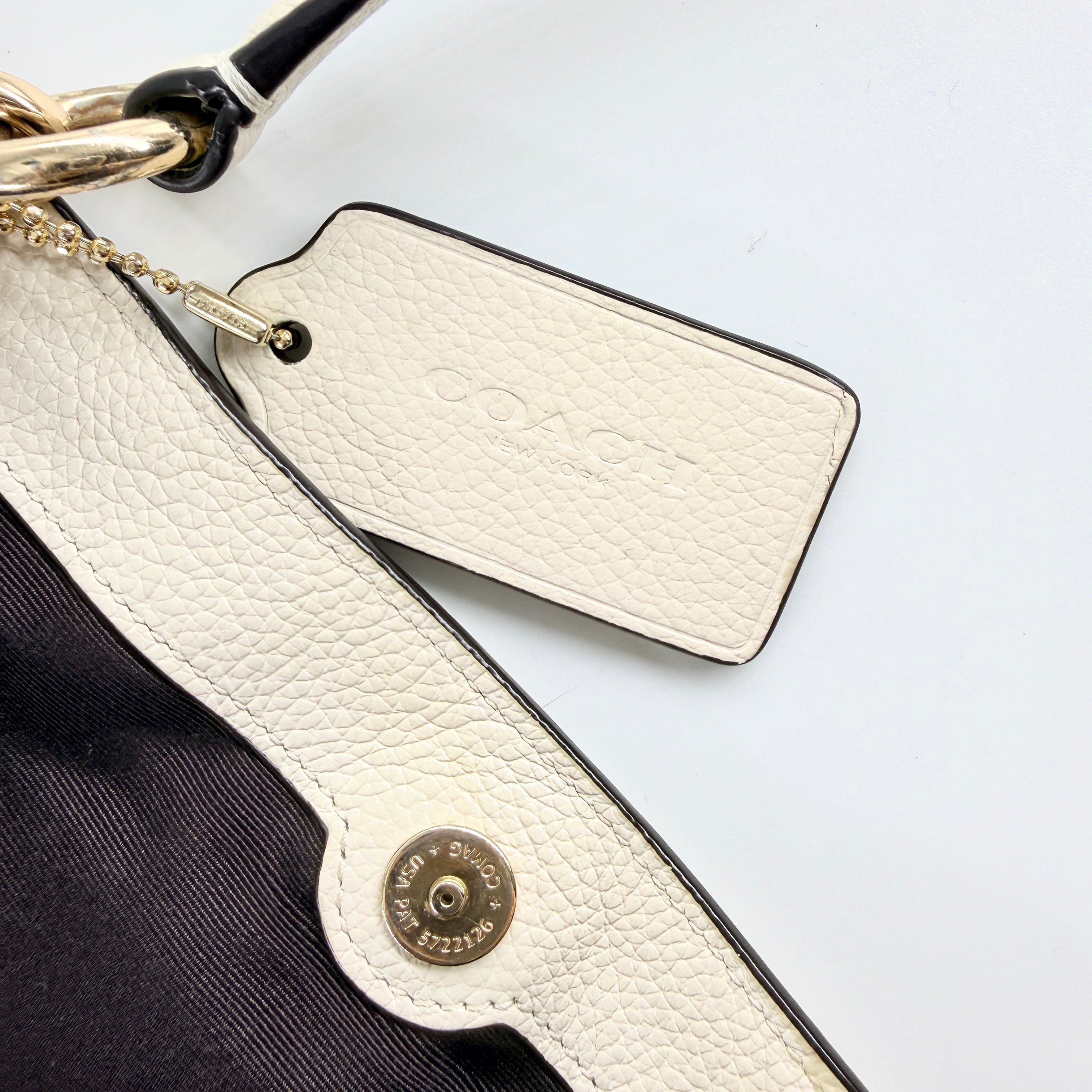 Coach Lexy Stardust Studded Chalk Hobo in ivory pebbled leather, adorned with mixed metal studs and dual handles.
