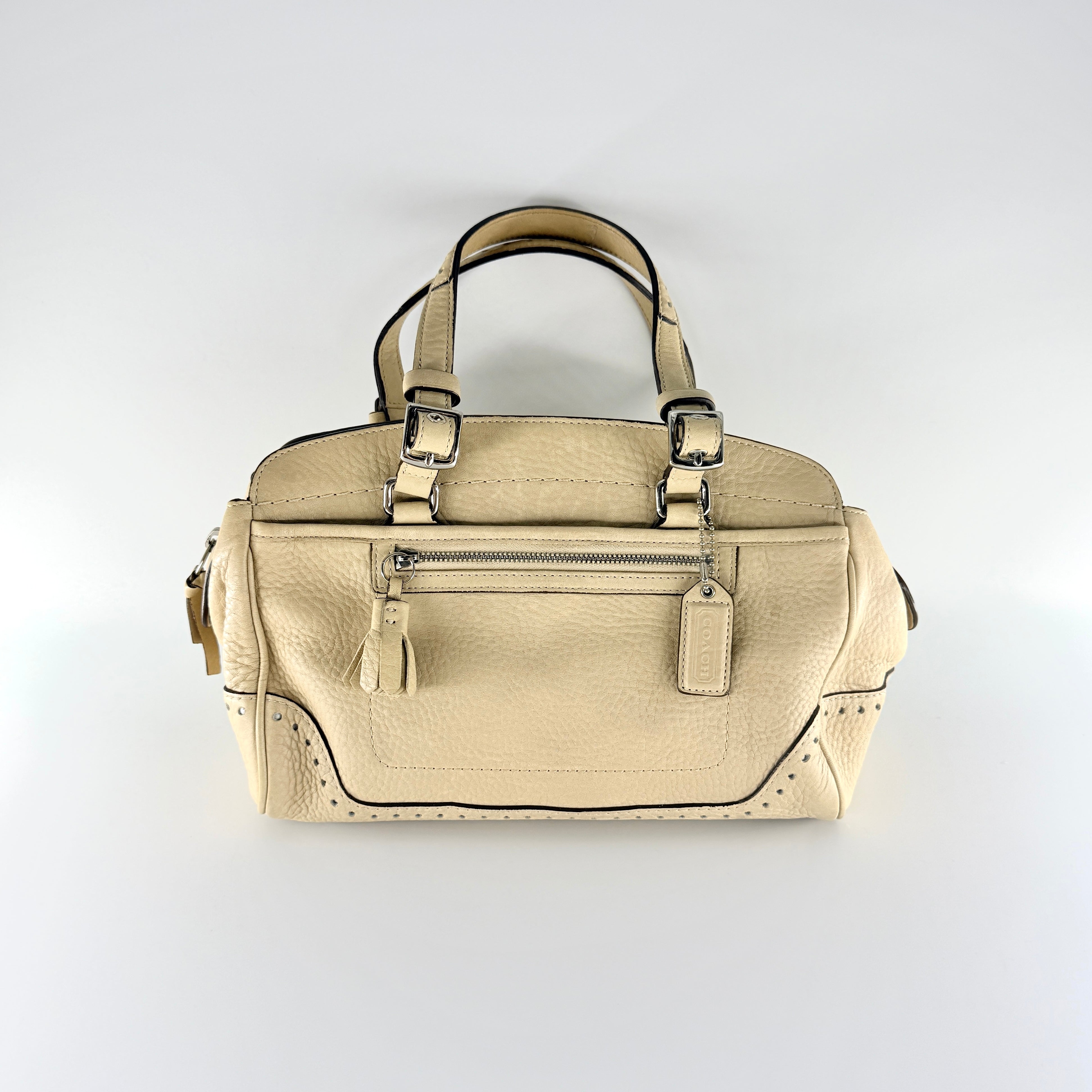Coach Hampton Sand Satchel in beige pebbled leather with structured dual handles, front zip pocket, and silver-tone hardware.