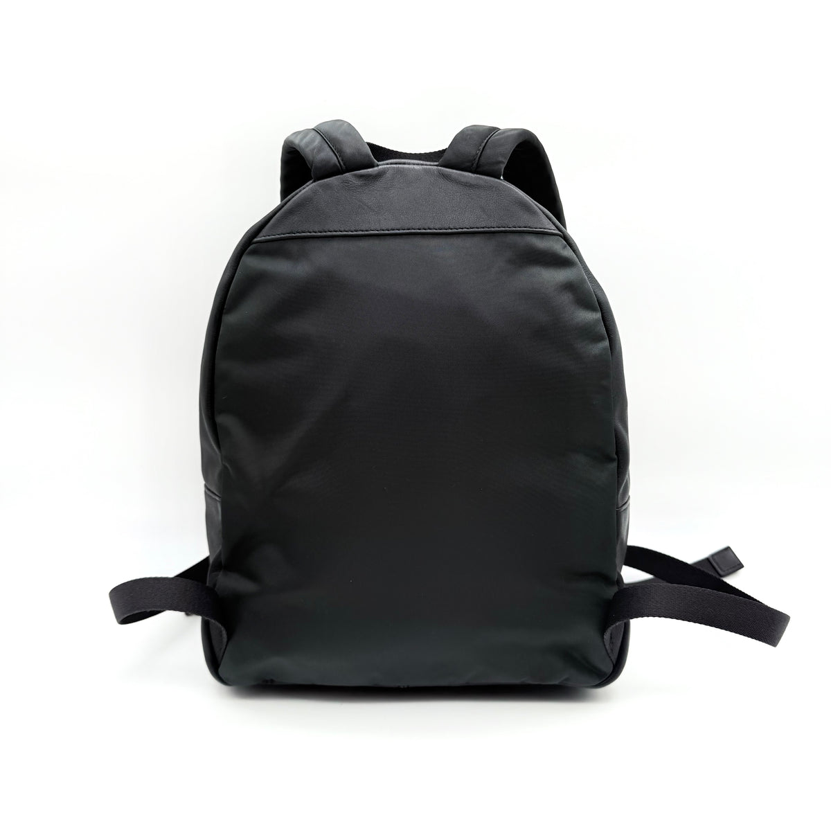 Coach Signature Charlie Backpack in brown and black canvas with gold-tone hardware and front zip pocket.
