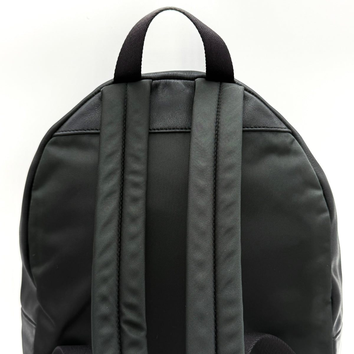 Coach Signature Charlie Backpack in brown and black canvas with gold-tone hardware and front zip pocket.