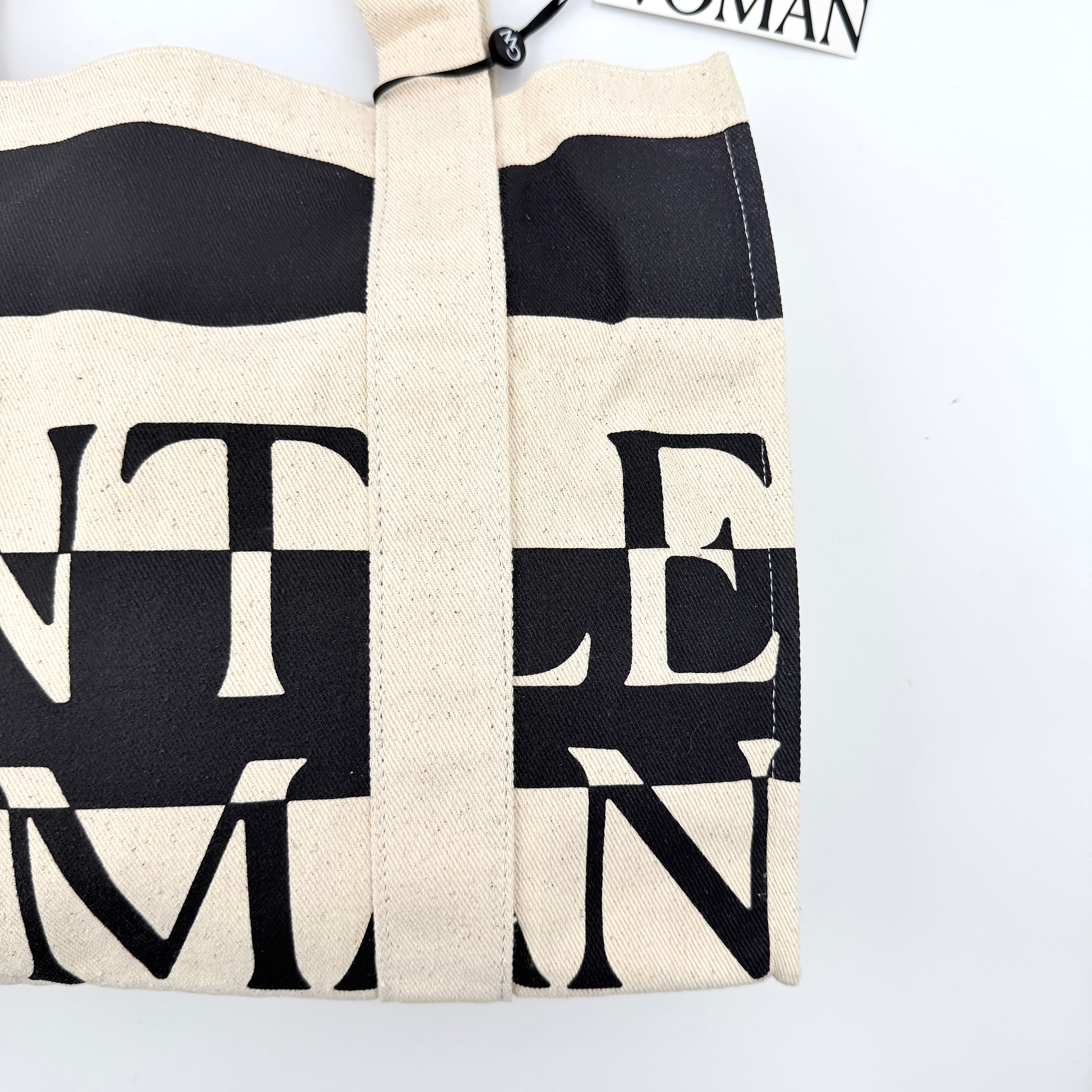Gentlewoman Canvas Tote Bag in cream and black canvas with bold oversized logo and twin carry handles.