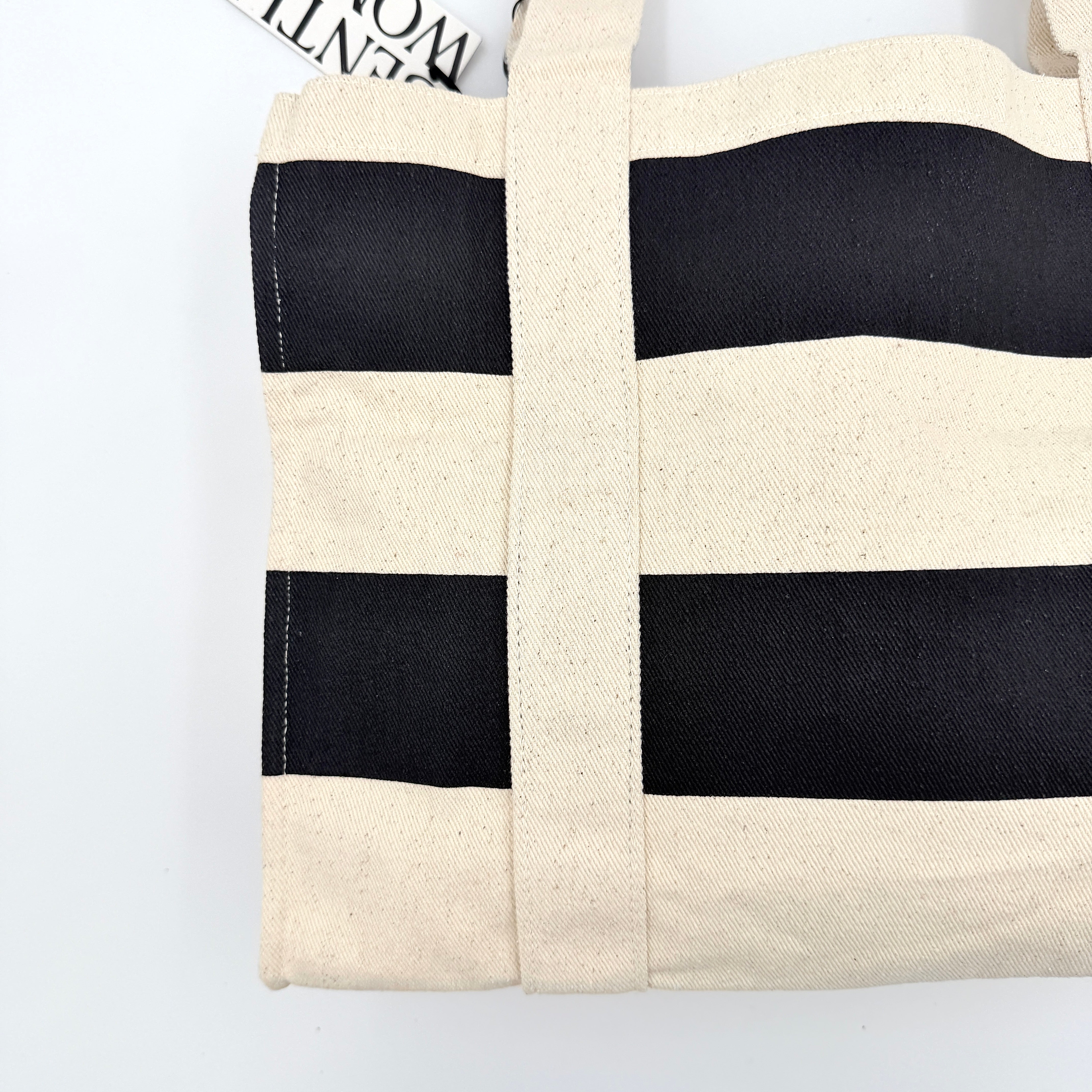 Gentlewoman Canvas Tote Bag in cream and black canvas with bold oversized logo and twin carry handles.