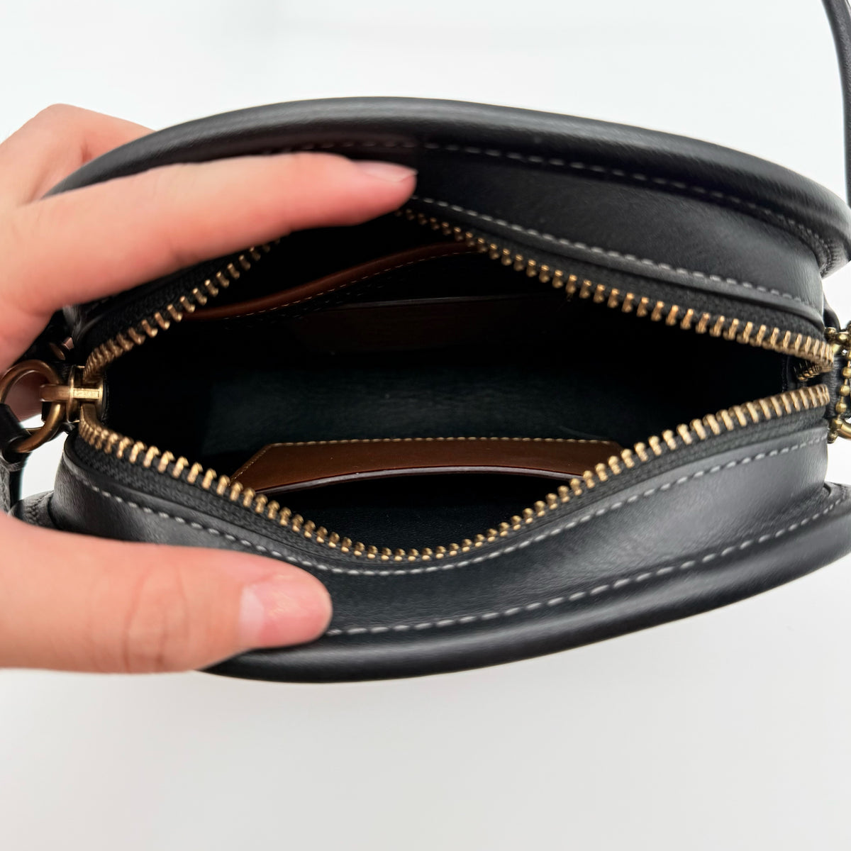 Coach Horse & Carriage Print Zip Crossbody Bag in black coated canvas with adjustable strap and gold hardware.