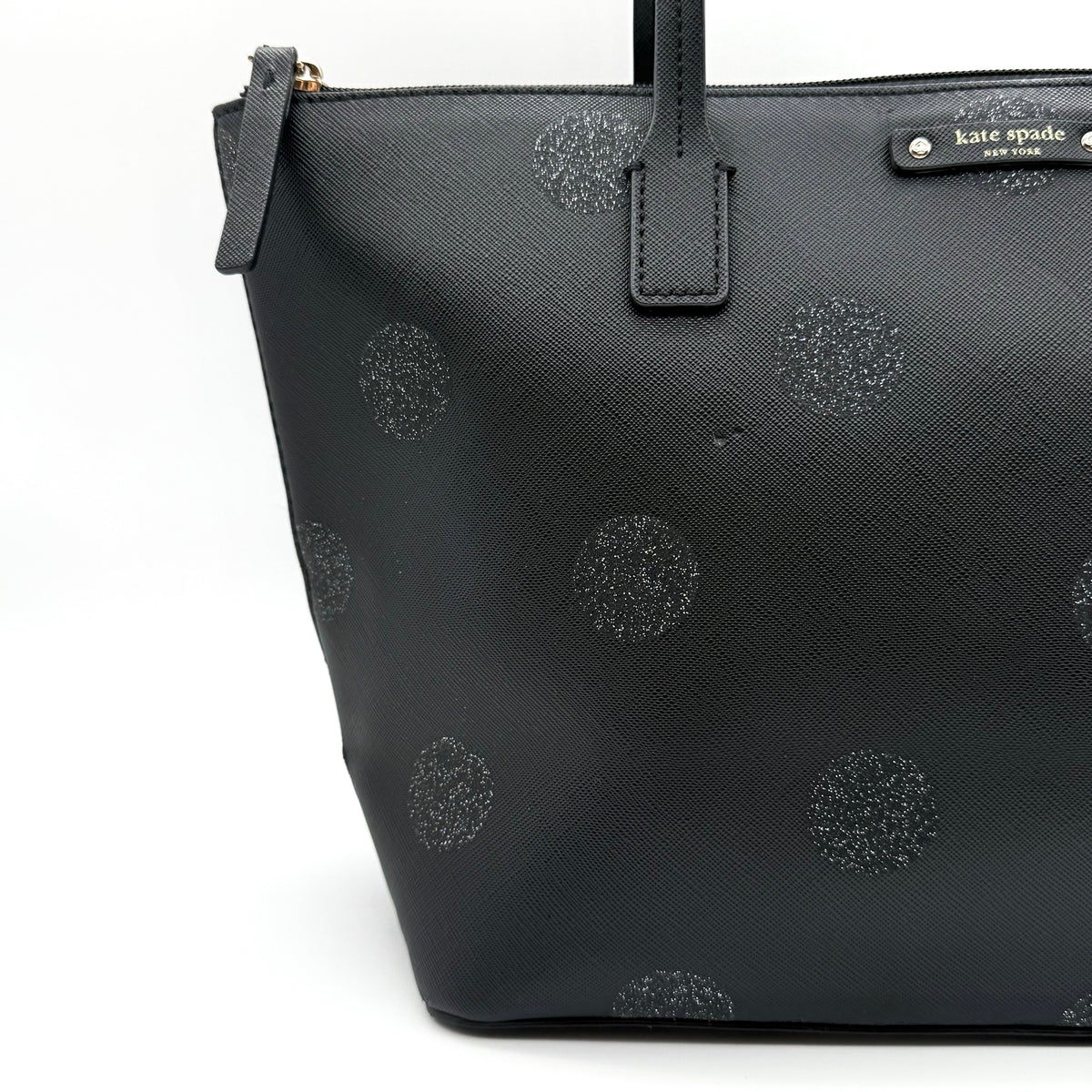 Front view of a Kate Spade black tote bag with glitter polka dots and dual handles.