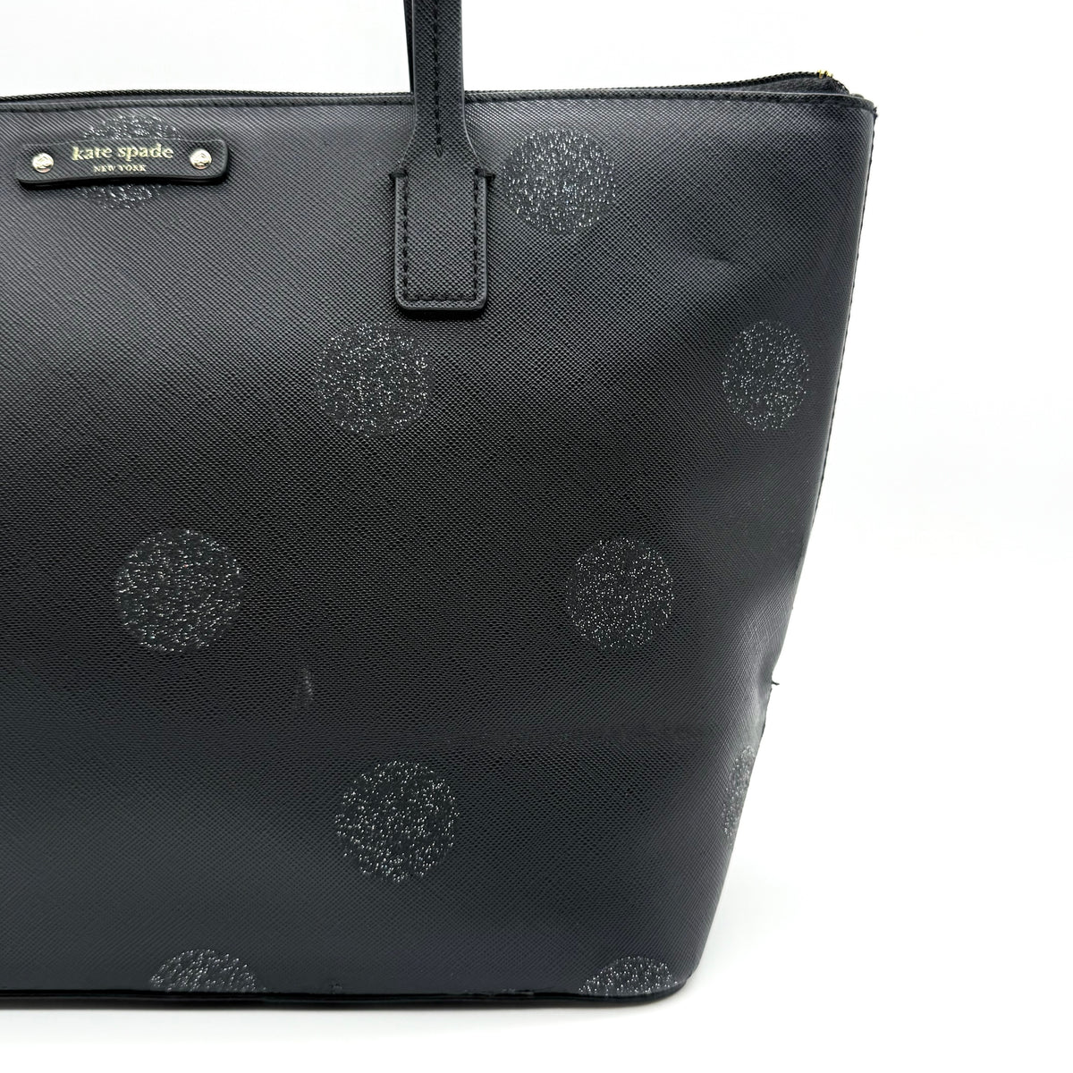 Front view of a Kate Spade black tote bag with glitter polka dots and dual handles.