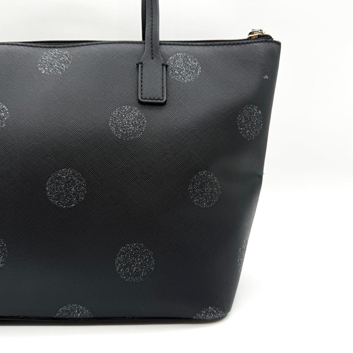 Front view of a Kate Spade black tote bag with glitter polka dots and dual handles.