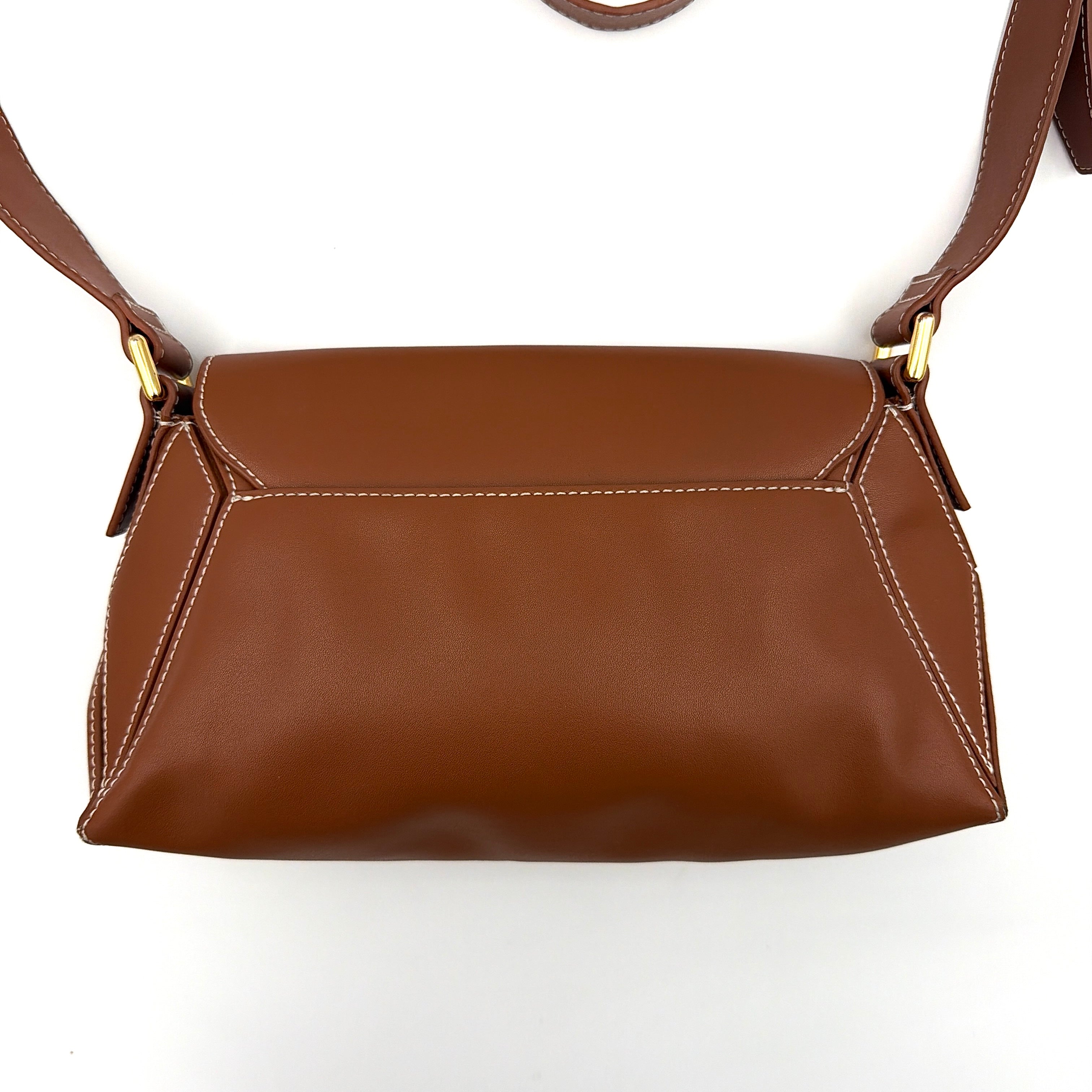Charles & Keith Nasrin Geometric Crossbody Bag in brown faux leather with angular stitching, gold-tone hardware, and adjustable strap.