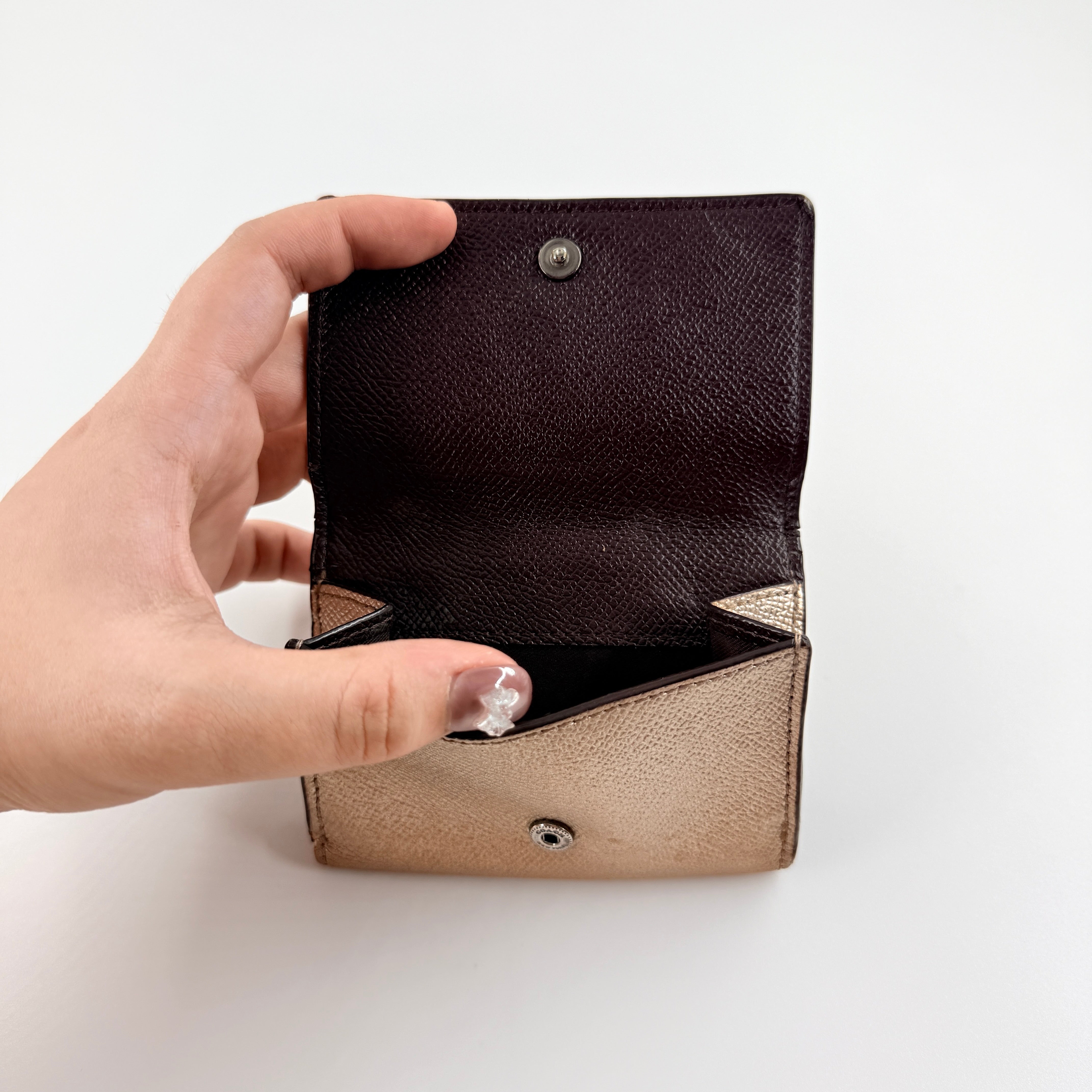 Coach metallic gold small flap wallet with silver logo plaque and crosshatch textured leather.