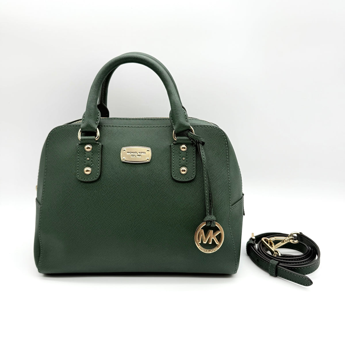 Michael Kors dark green Saffiano leather dome satchel with gold hardware and detachable strap, shown against a white background.