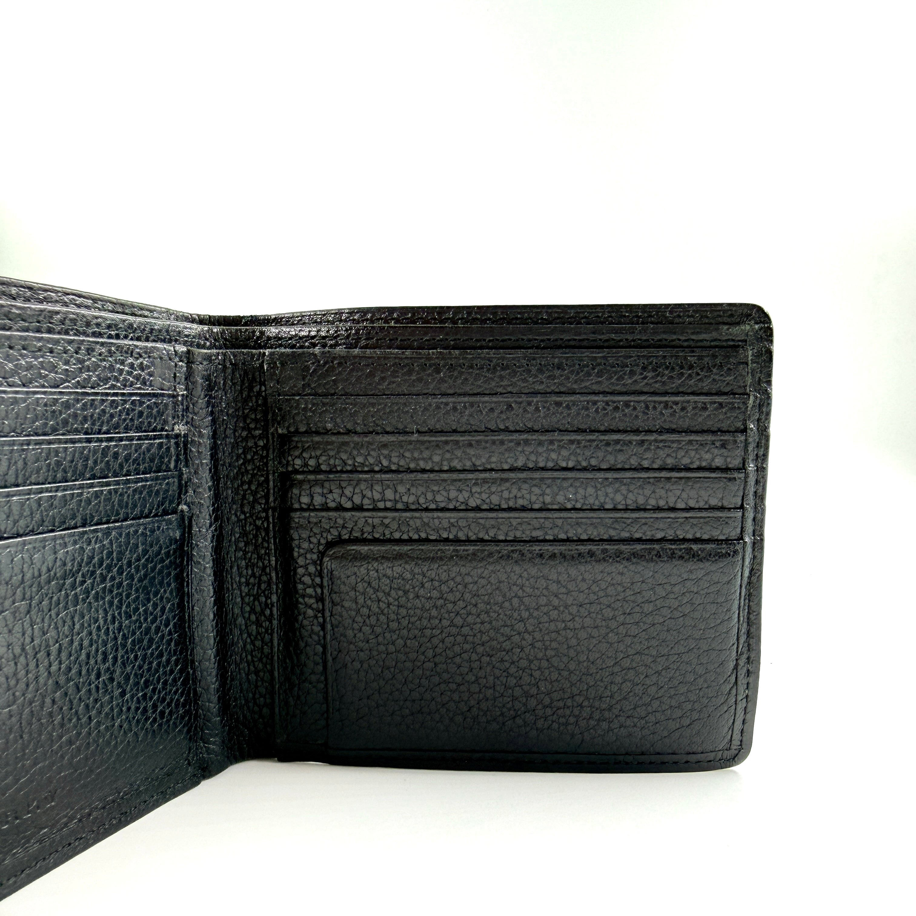 Burberry Nova Check bifold wallet in refined black grained leather with discreet embossed logo, presenting a minimal and polished silhouette.
