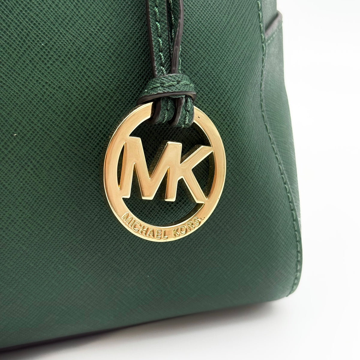 Michael Kors dark green Saffiano leather dome satchel with gold hardware and detachable strap, shown against a white background.