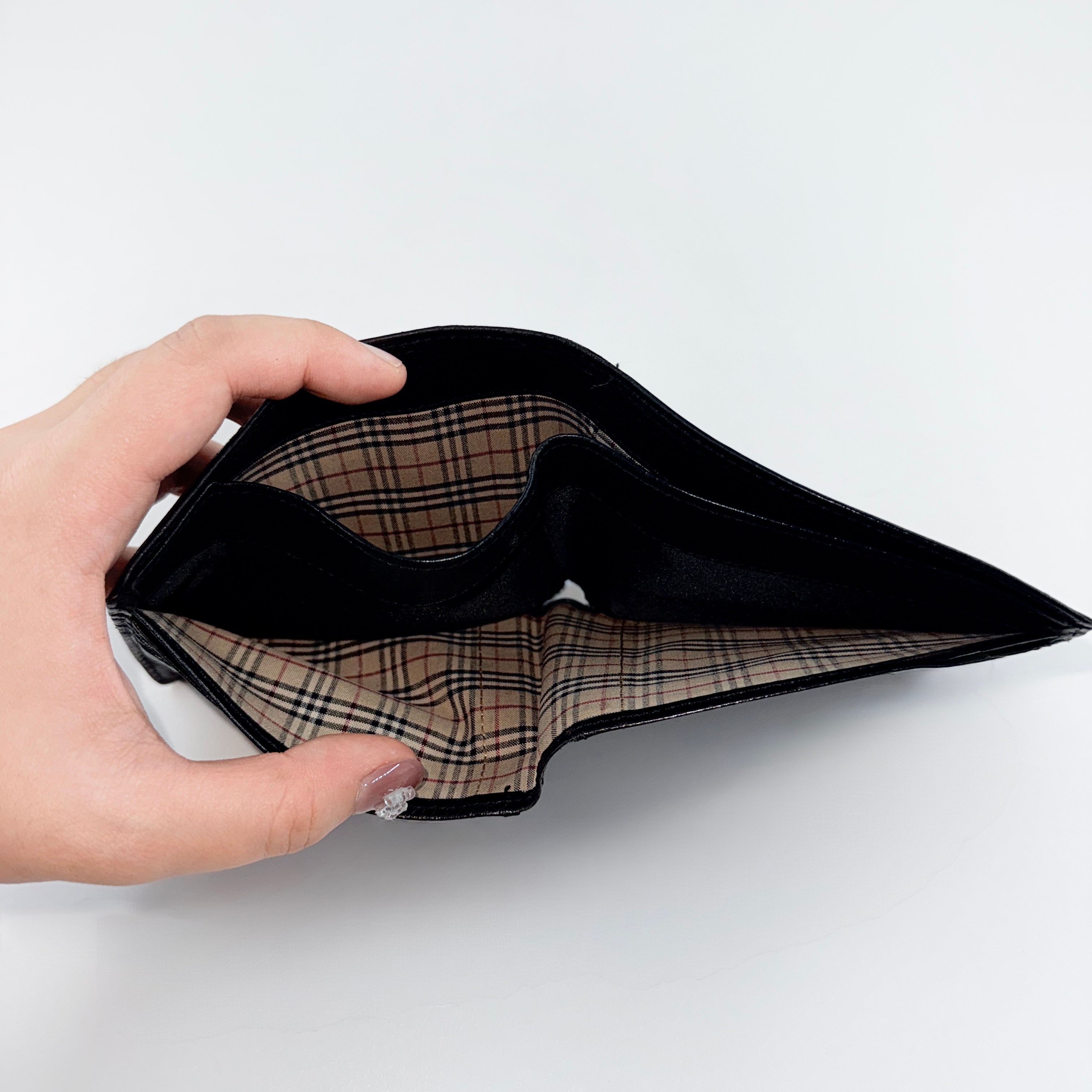 Burberry Nova Check bifold wallet in refined black grained leather with discreet embossed logo, presenting a minimal and polished silhouette.