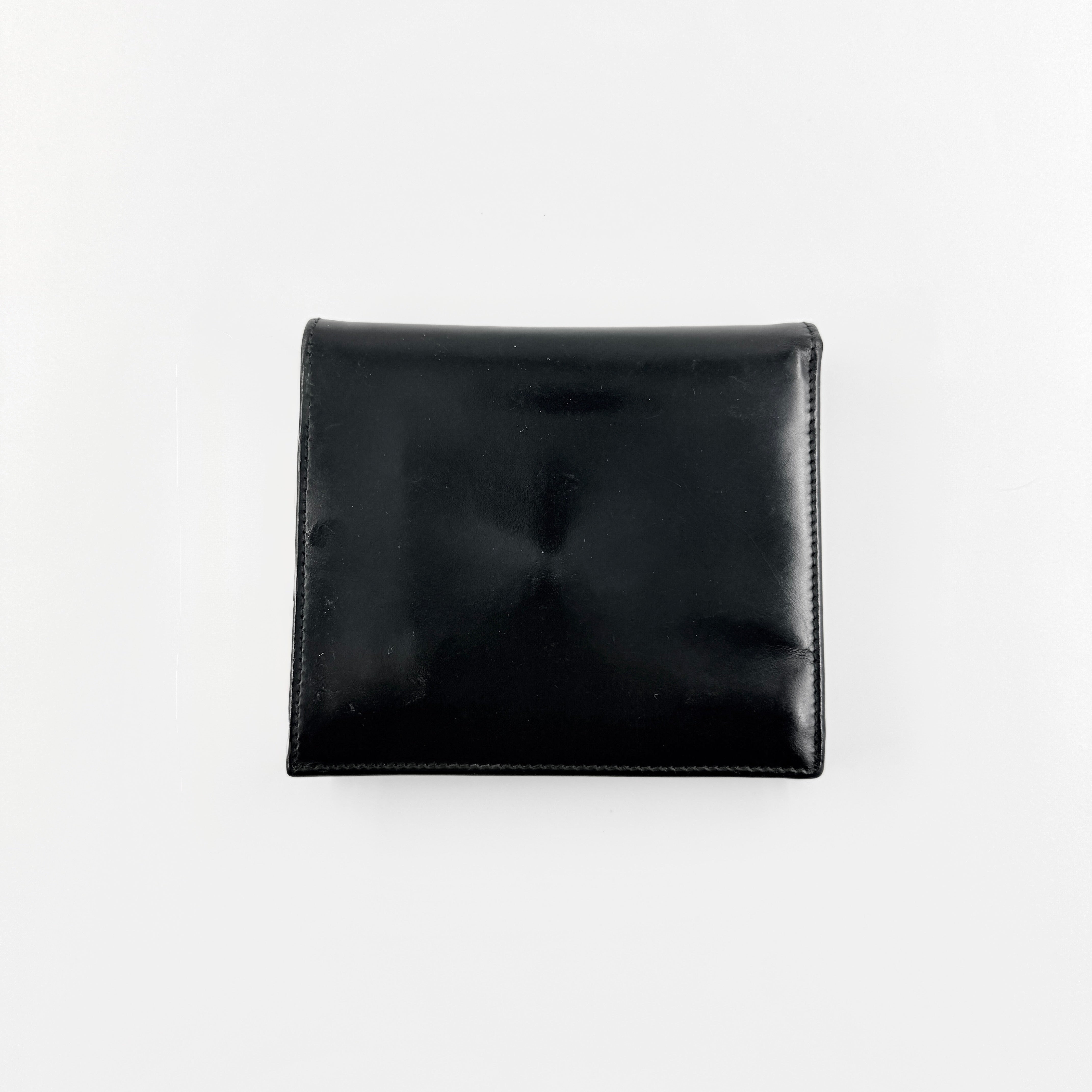 Gucci G Logo Bifold Wallet in black leather featuring a bold geometric G plaque and meticulously stitched edges.