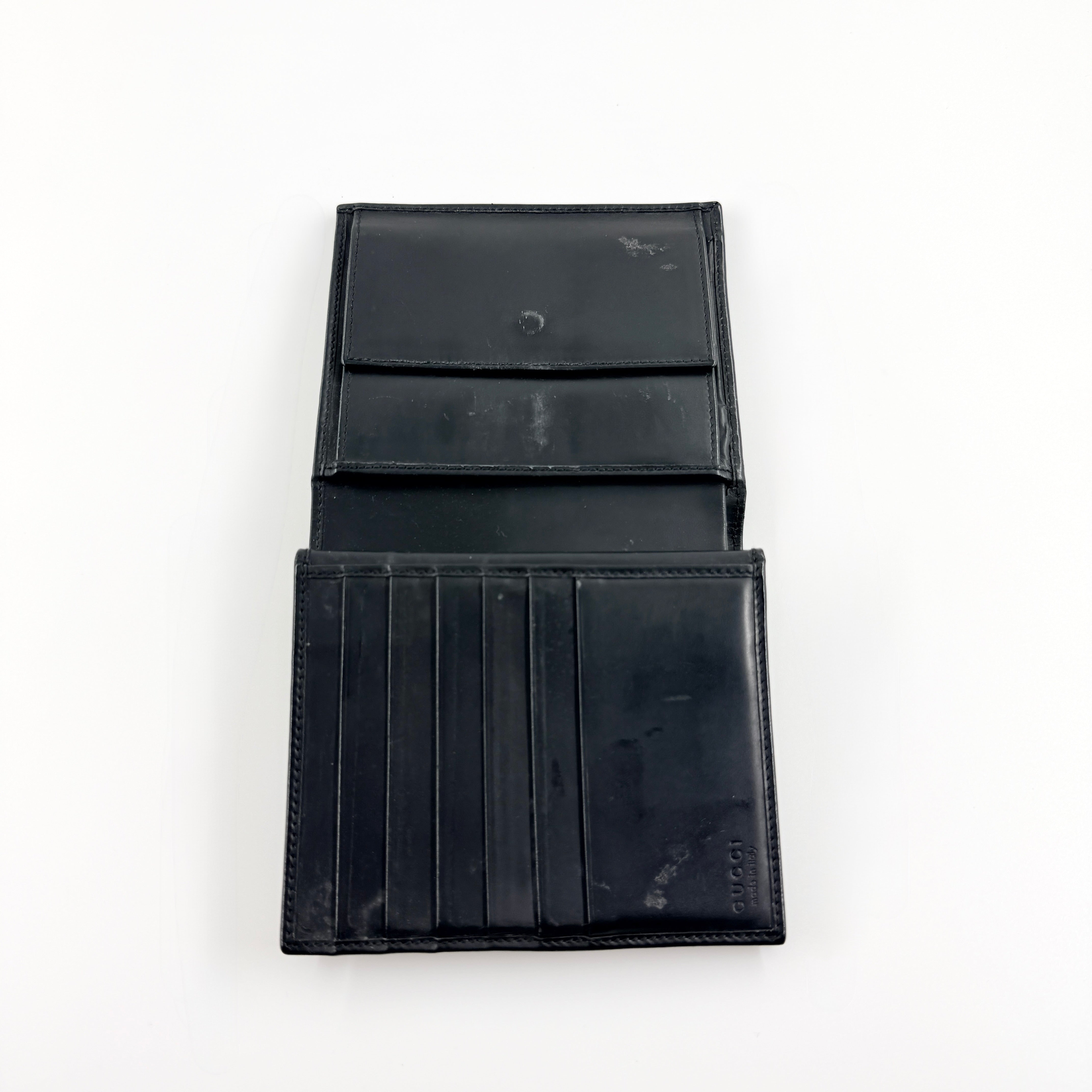 Gucci G Logo Bifold Wallet in black leather featuring a bold geometric G plaque and meticulously stitched edges.