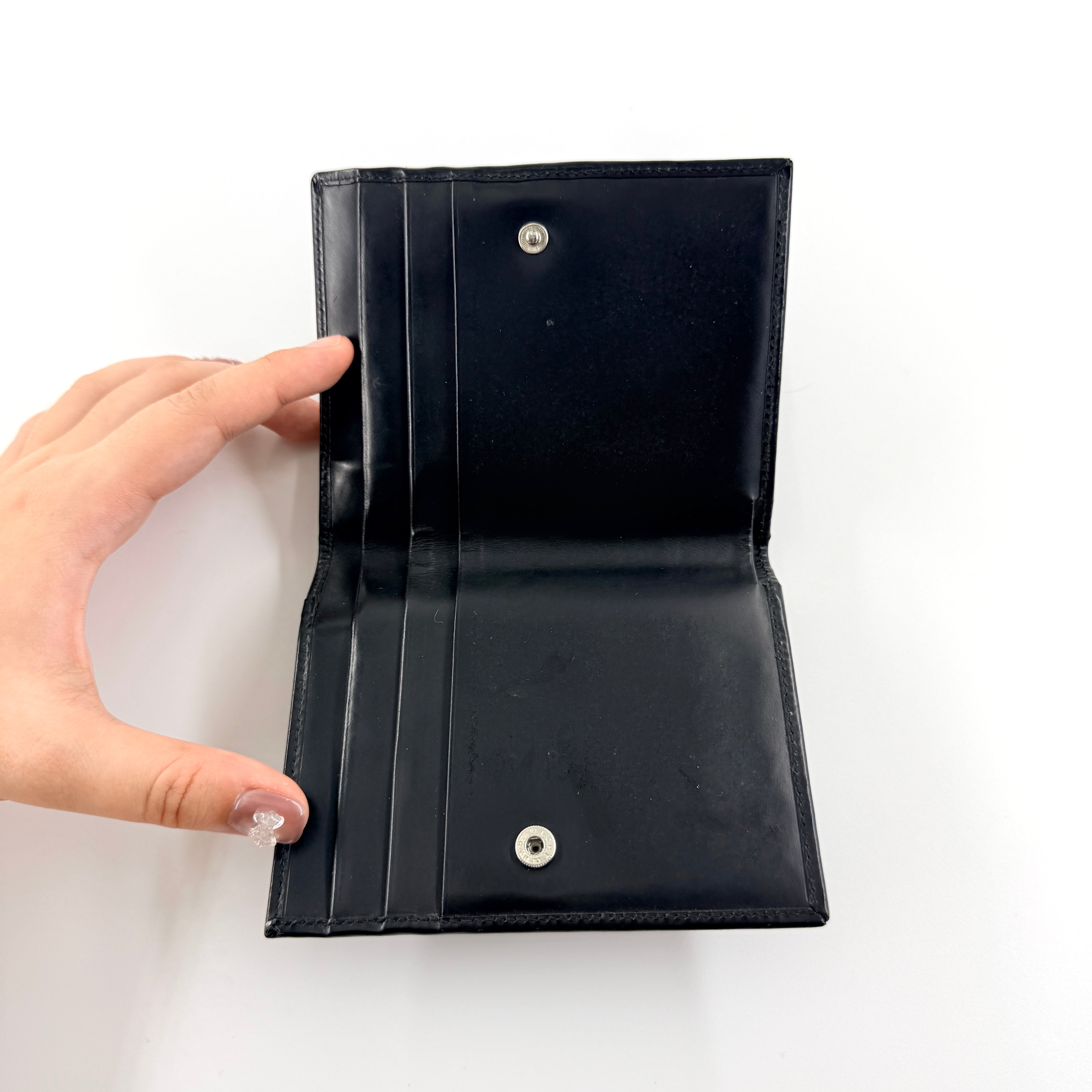 Gucci G Logo Bifold Wallet in black leather featuring a bold geometric G plaque and meticulously stitched edges.