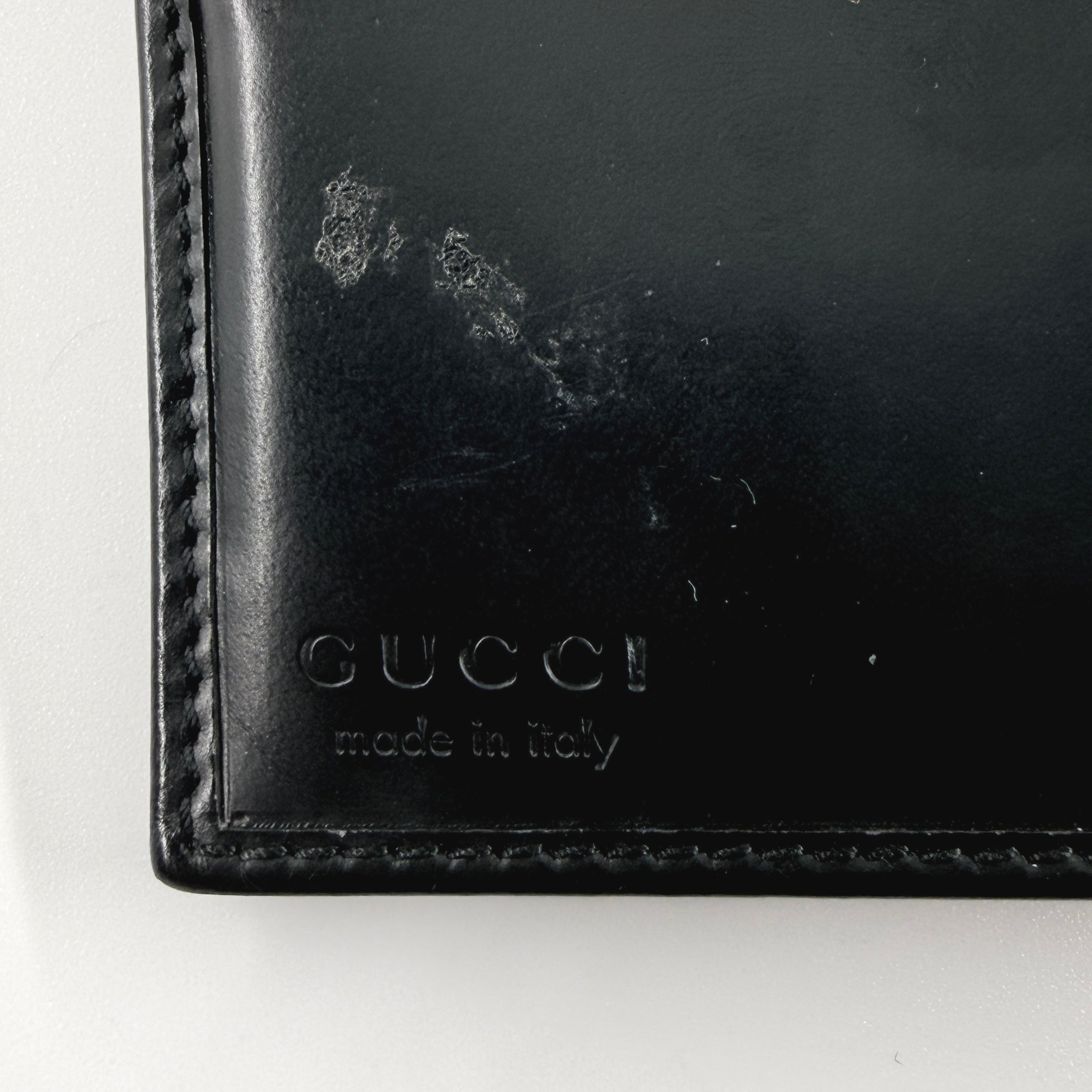 Gucci G Logo Bifold Wallet in black leather featuring a bold geometric G plaque and meticulously stitched edges.