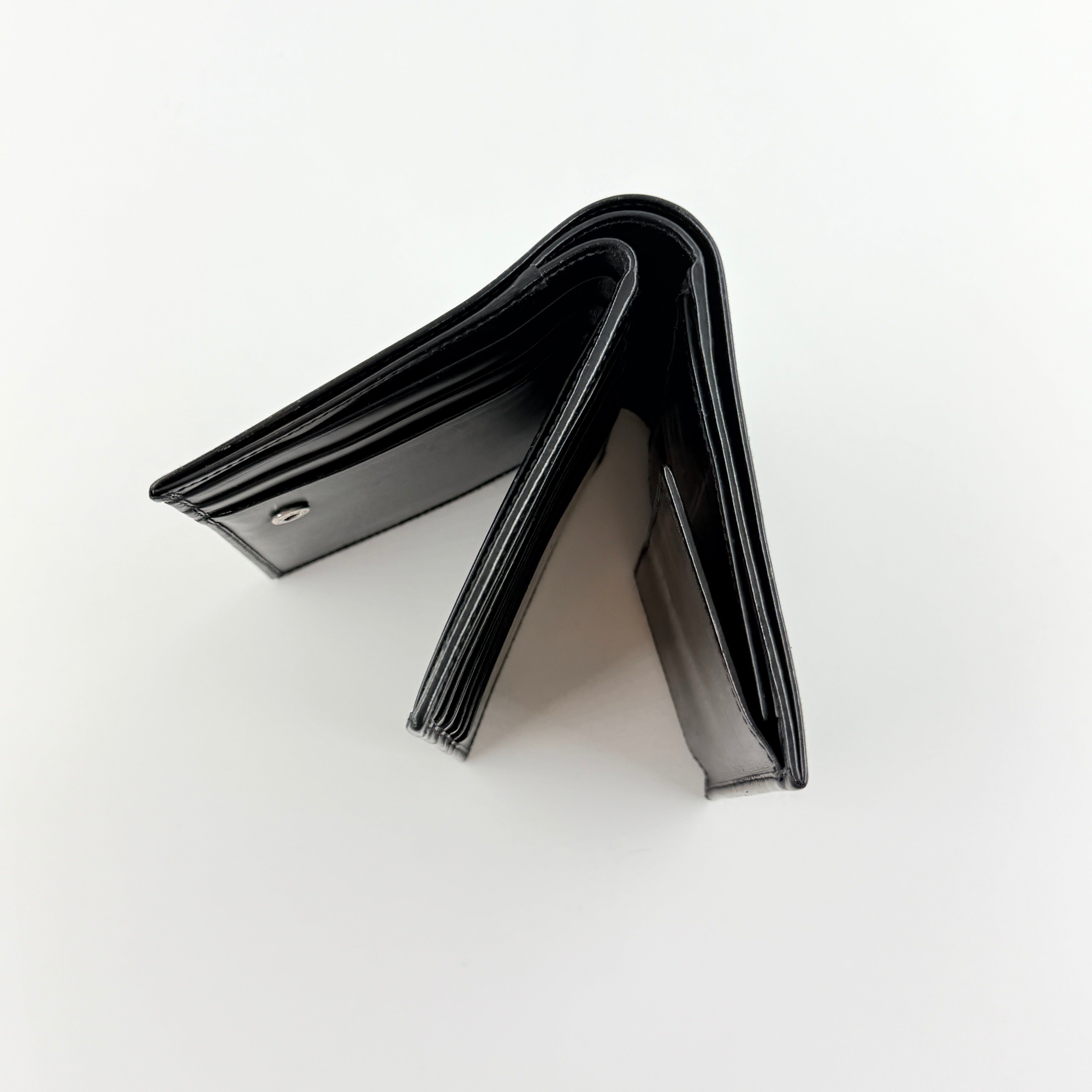 Gucci G Logo Bifold Wallet in black leather featuring a bold geometric G plaque and meticulously stitched edges.