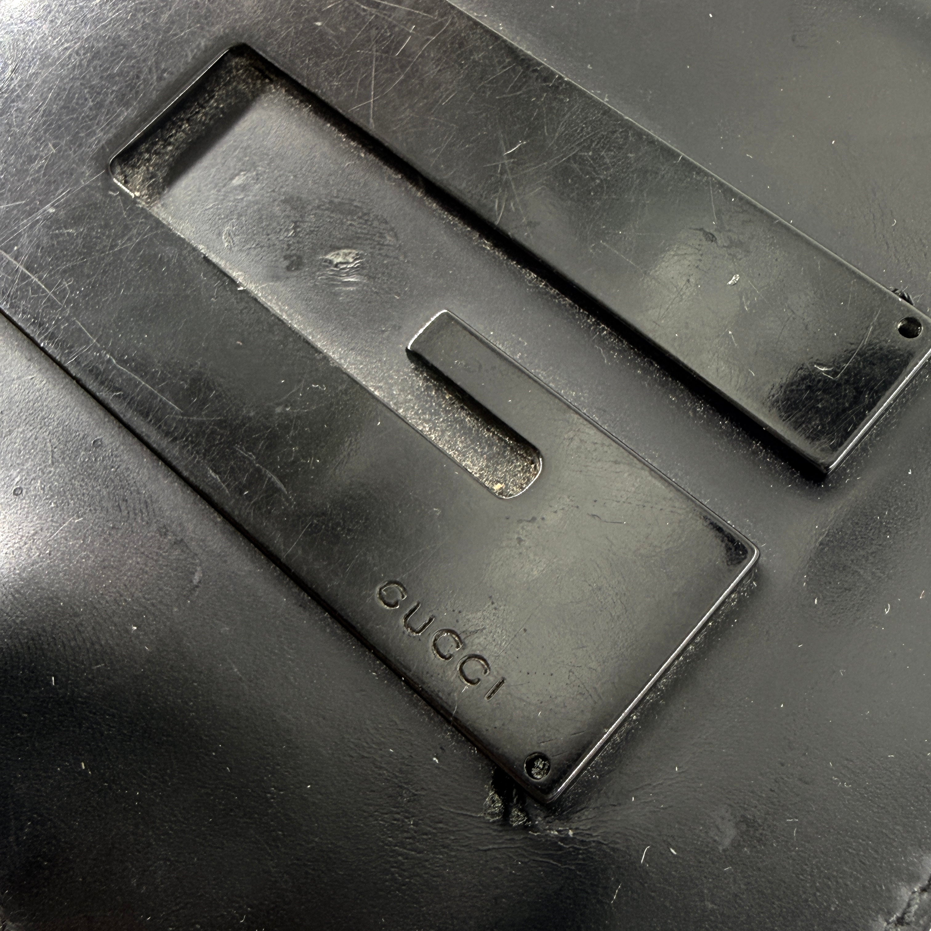 Gucci G Logo Bifold Wallet in black leather featuring a bold geometric G plaque and meticulously stitched edges.