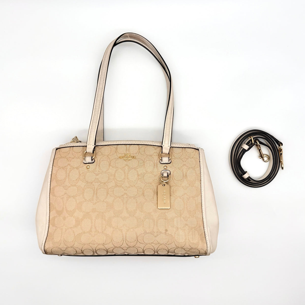 Coach Stanton Carryall in beige and ivory jacquard canvas with gold hardware and detachable strap, styled for everyday versatility.