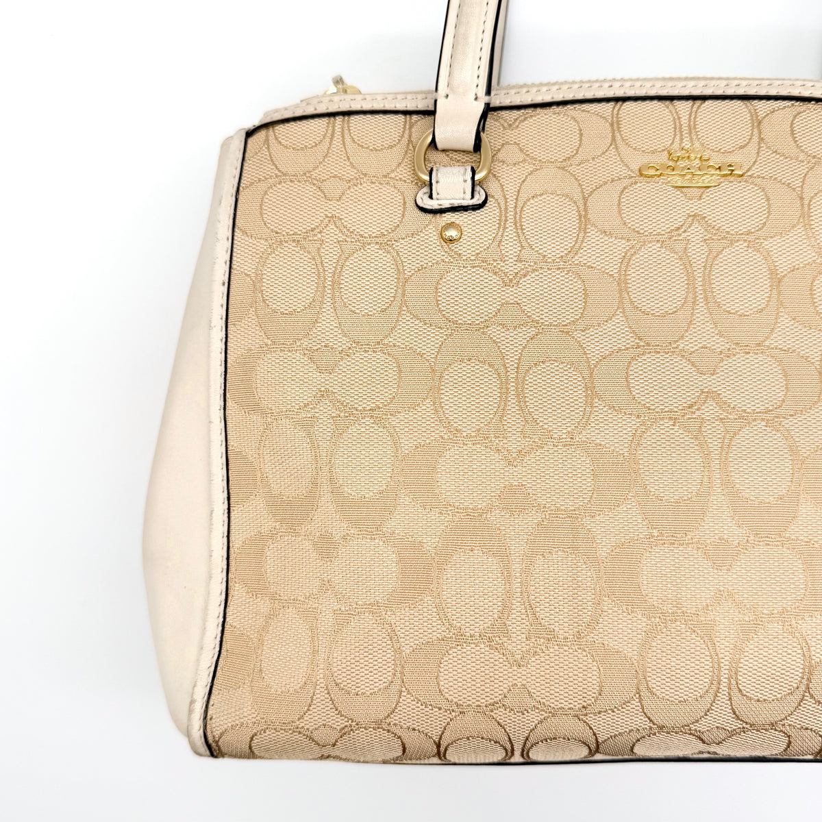 Coach Stanton Carryall in beige and ivory jacquard canvas with gold hardware and detachable strap, styled for everyday versatility.
