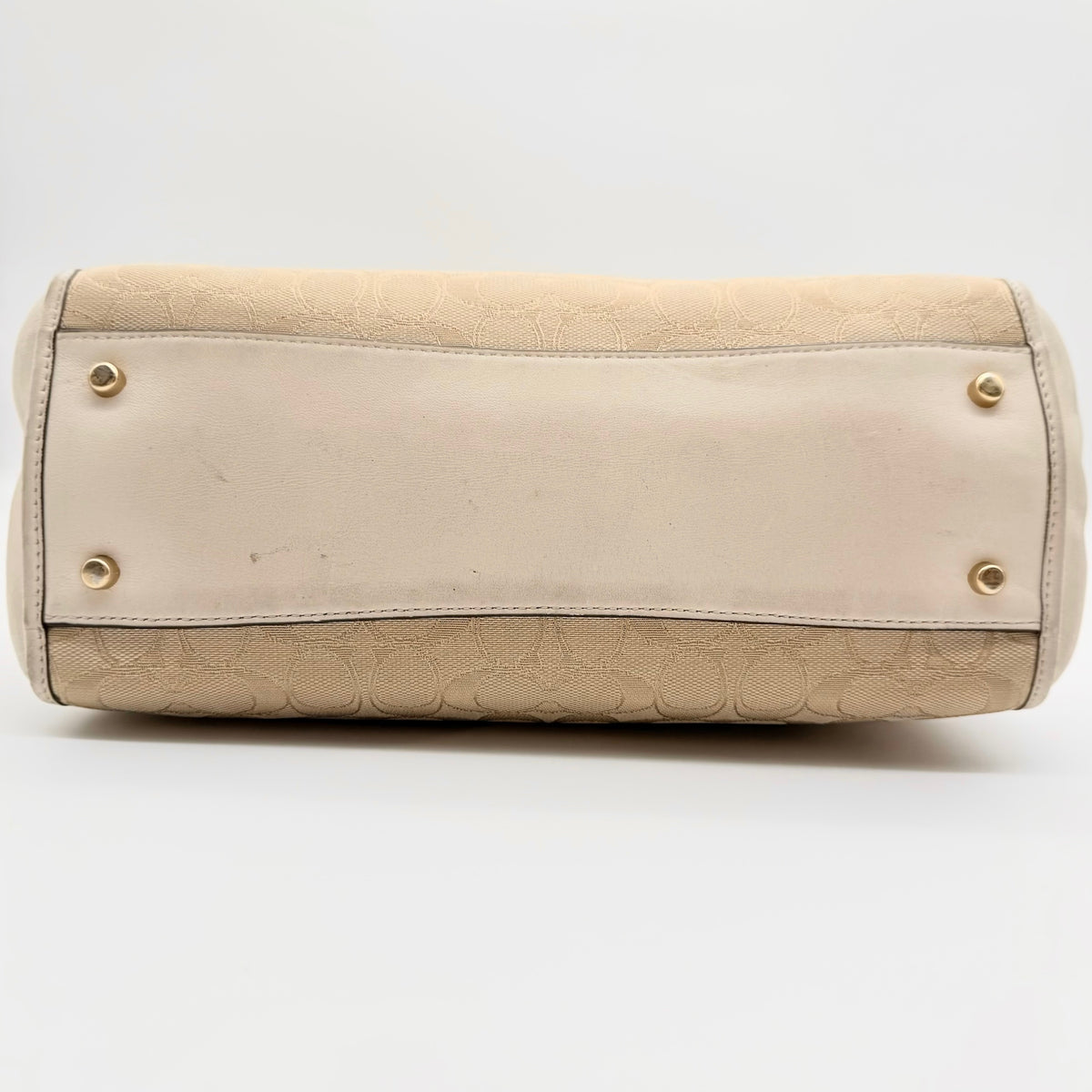 Coach Stanton Carryall in beige and ivory jacquard canvas with gold hardware and detachable strap, styled for everyday versatility.