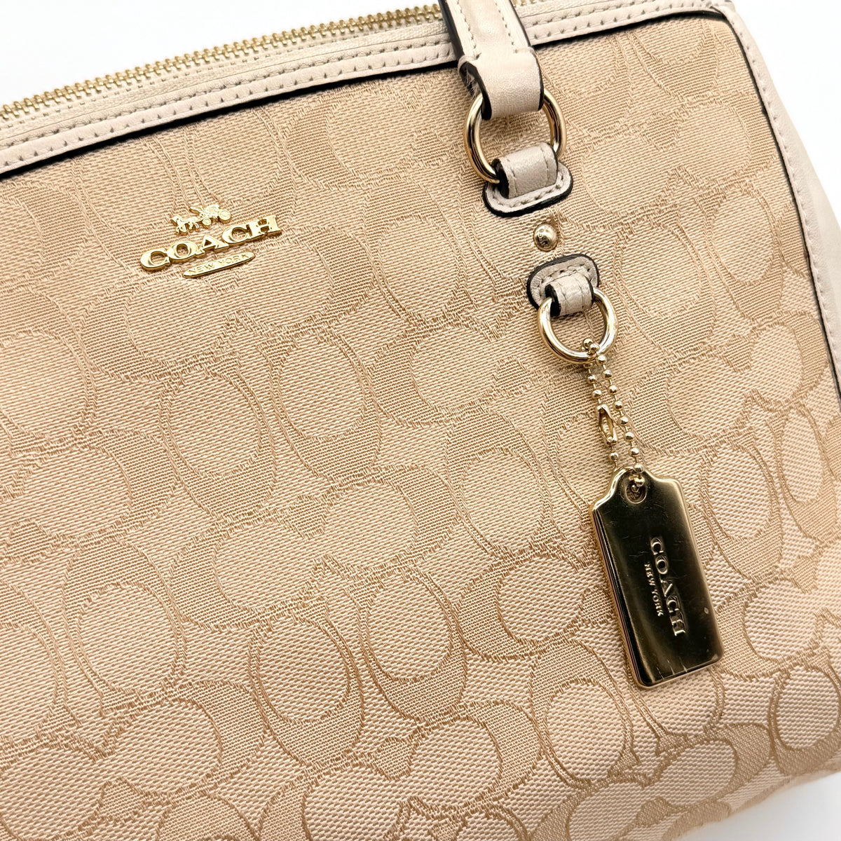 Coach Stanton Carryall in beige and ivory jacquard canvas with gold hardware and detachable strap, styled for everyday versatility.