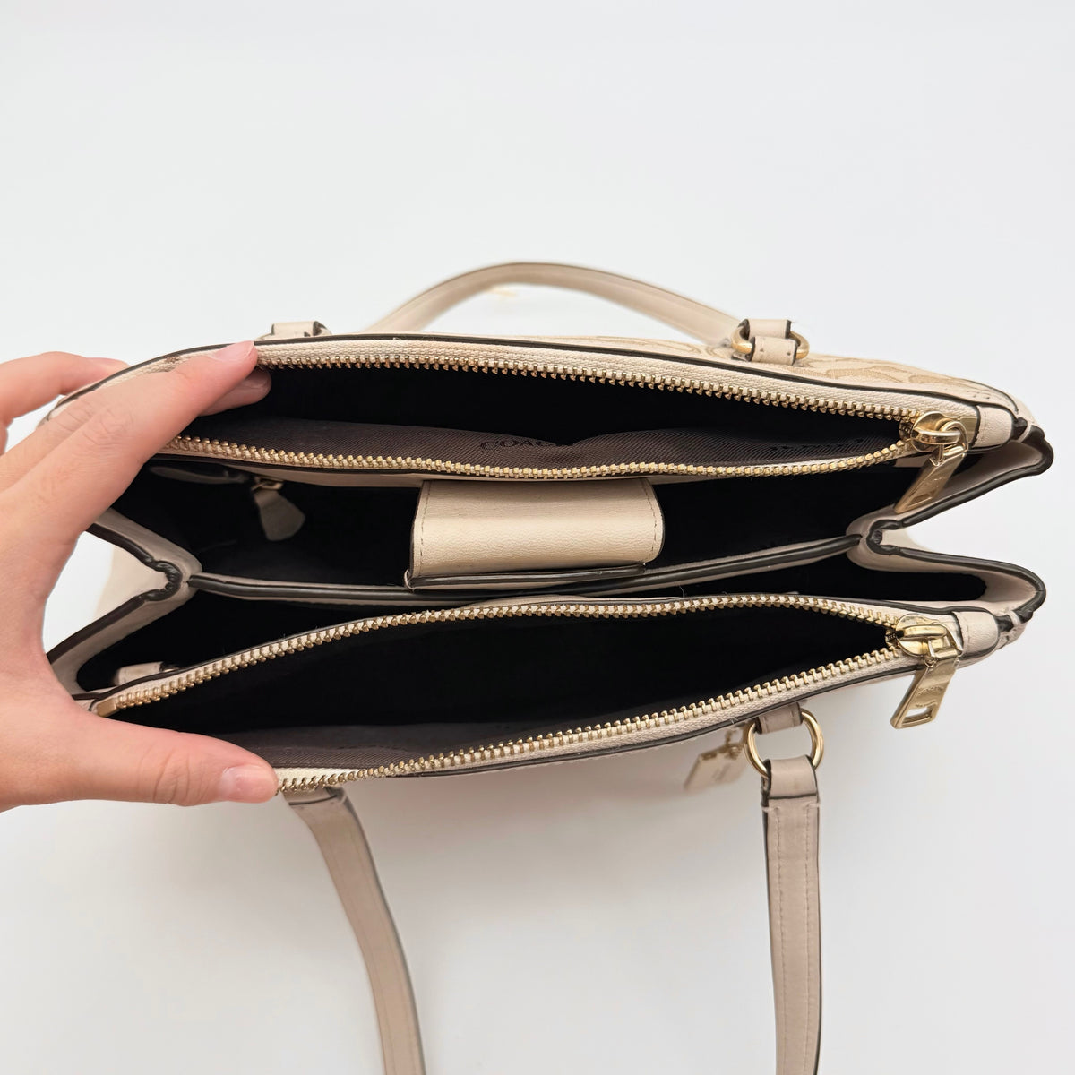 Coach Stanton Carryall in beige and ivory jacquard canvas with gold hardware and detachable strap, styled for everyday versatility.