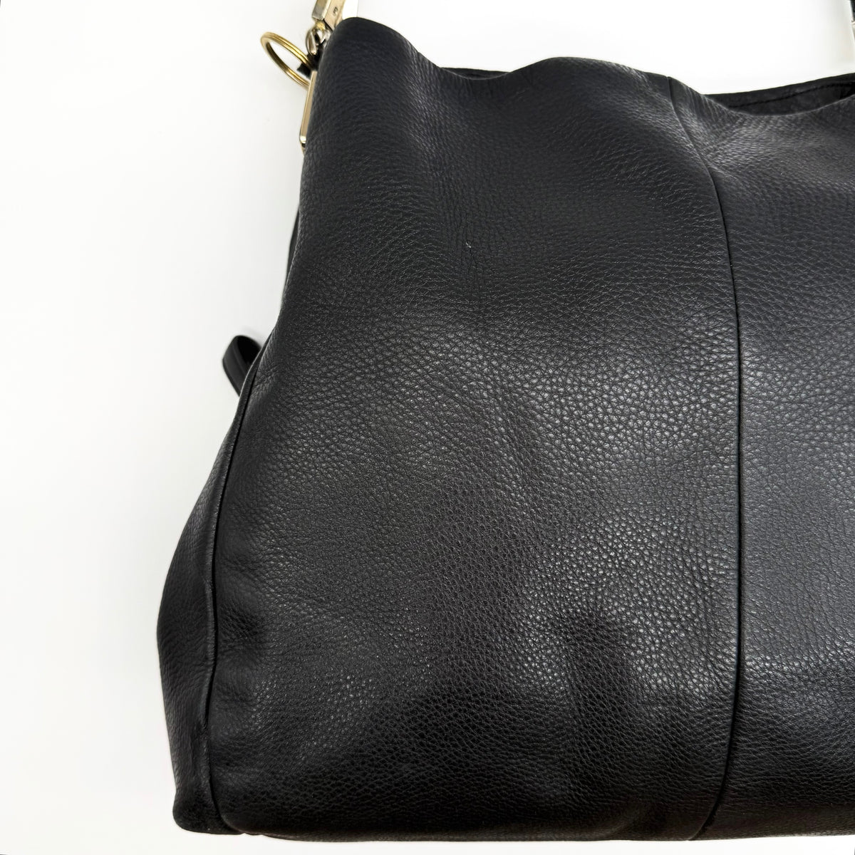Coach Madison Phoebe Shoulder Bag in black grained leather with gold hardware and dual handles, shown against a white background.