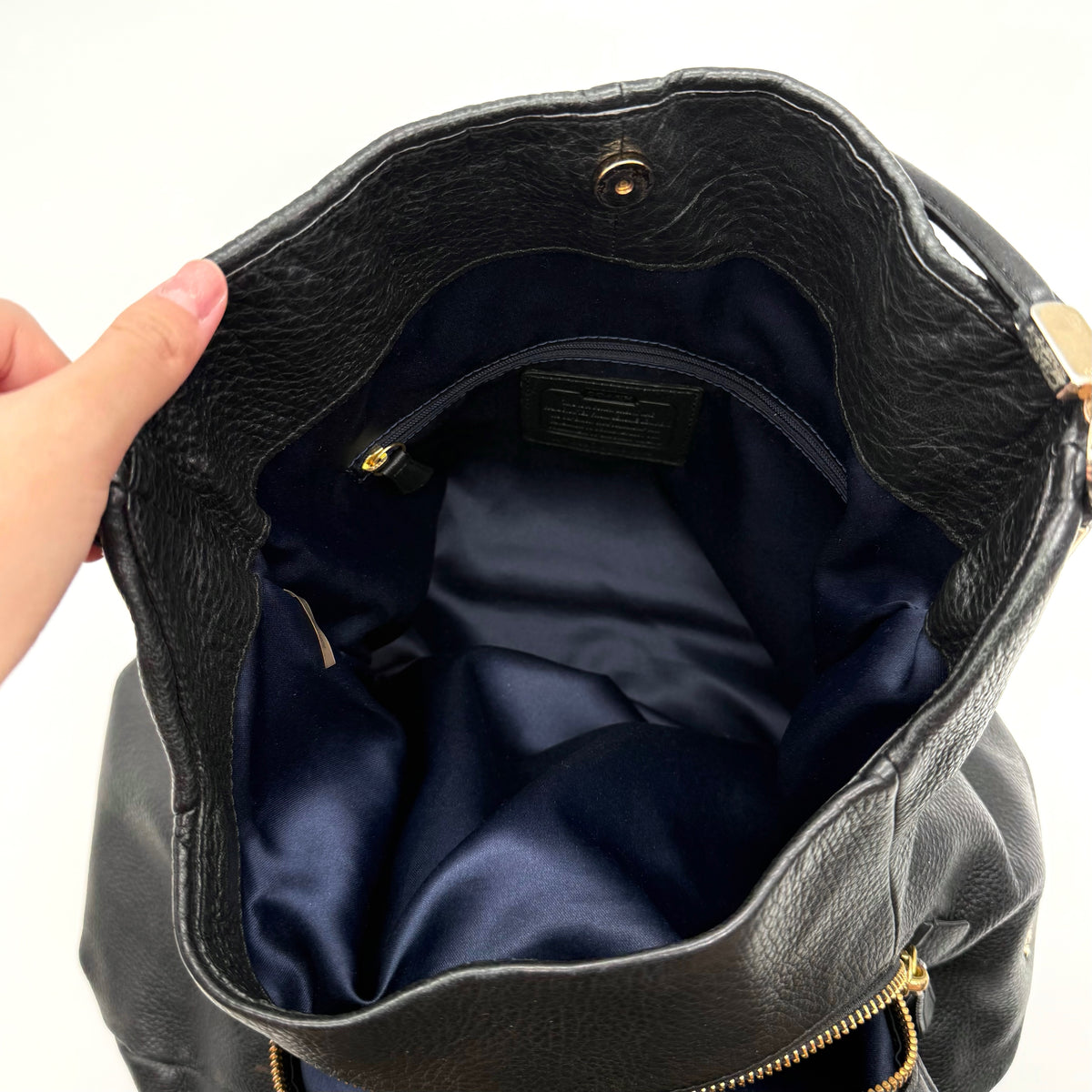 Coach Madison Phoebe Shoulder Bag in black grained leather with gold hardware and dual handles, shown against a white background.