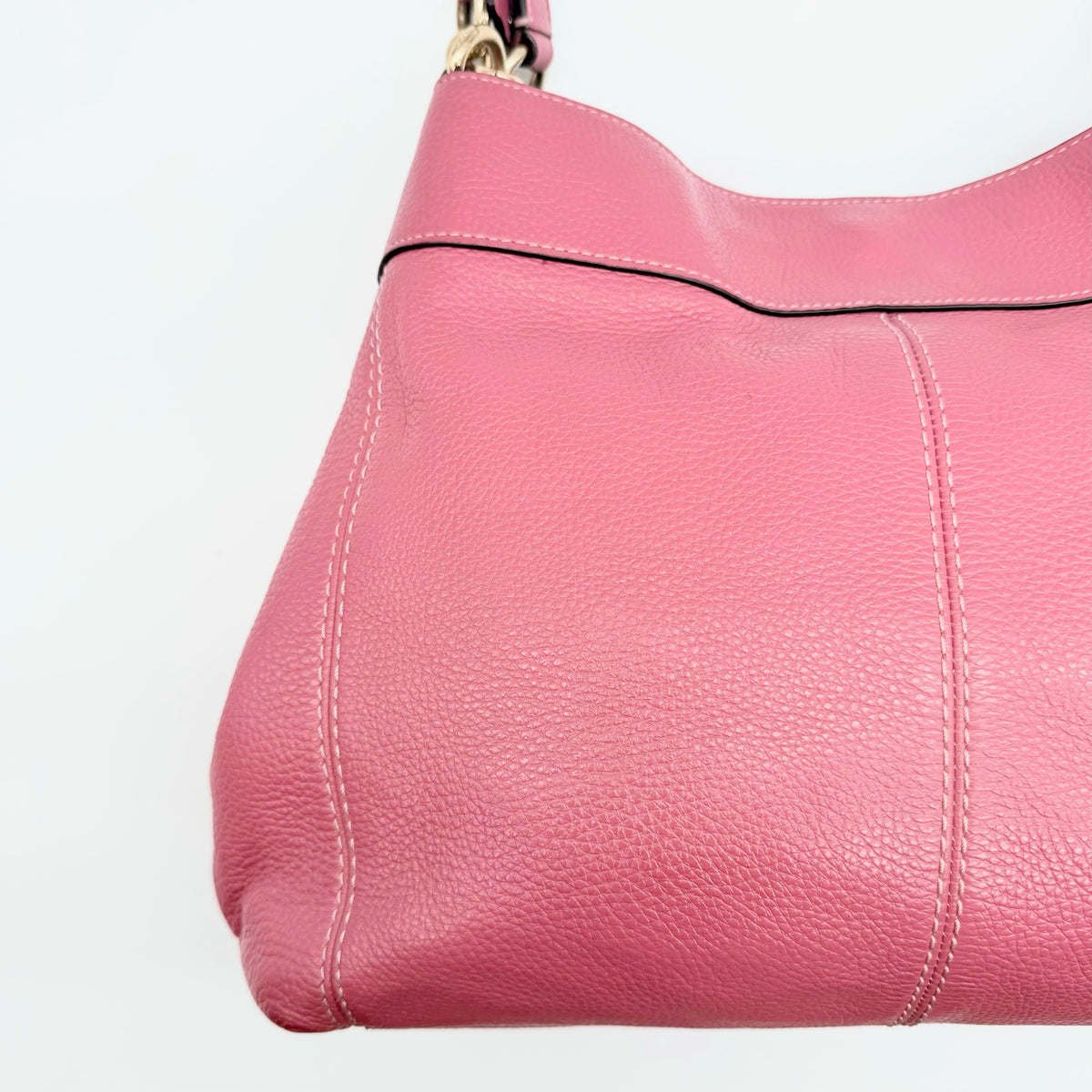 Coach Lexy Shoulder Bag in pink pebbled leather with gold hardware and dual straps, shown against a white background.