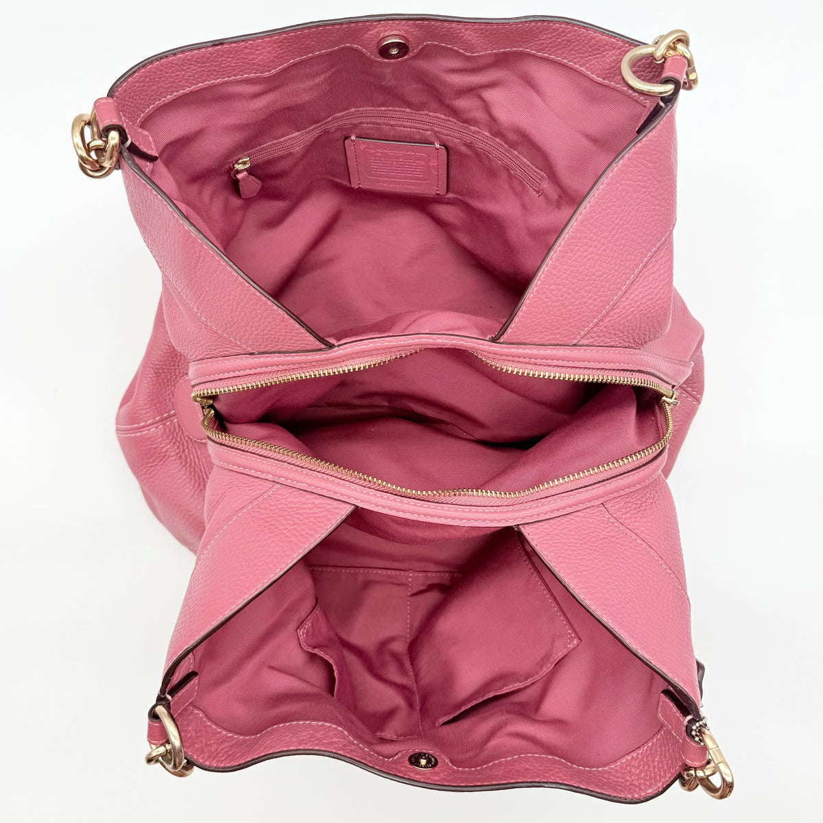 Coach Lexy Shoulder Bag in pink pebbled leather with gold hardware and dual straps, shown against a white background.