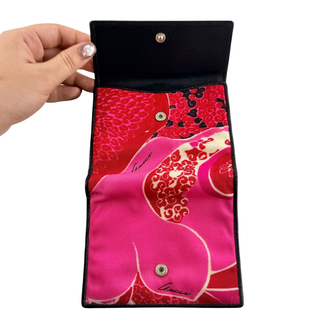 Gucci compact wallet with vibrant pink floral canvas, black leather trim and a silver-tone clasp, front view.