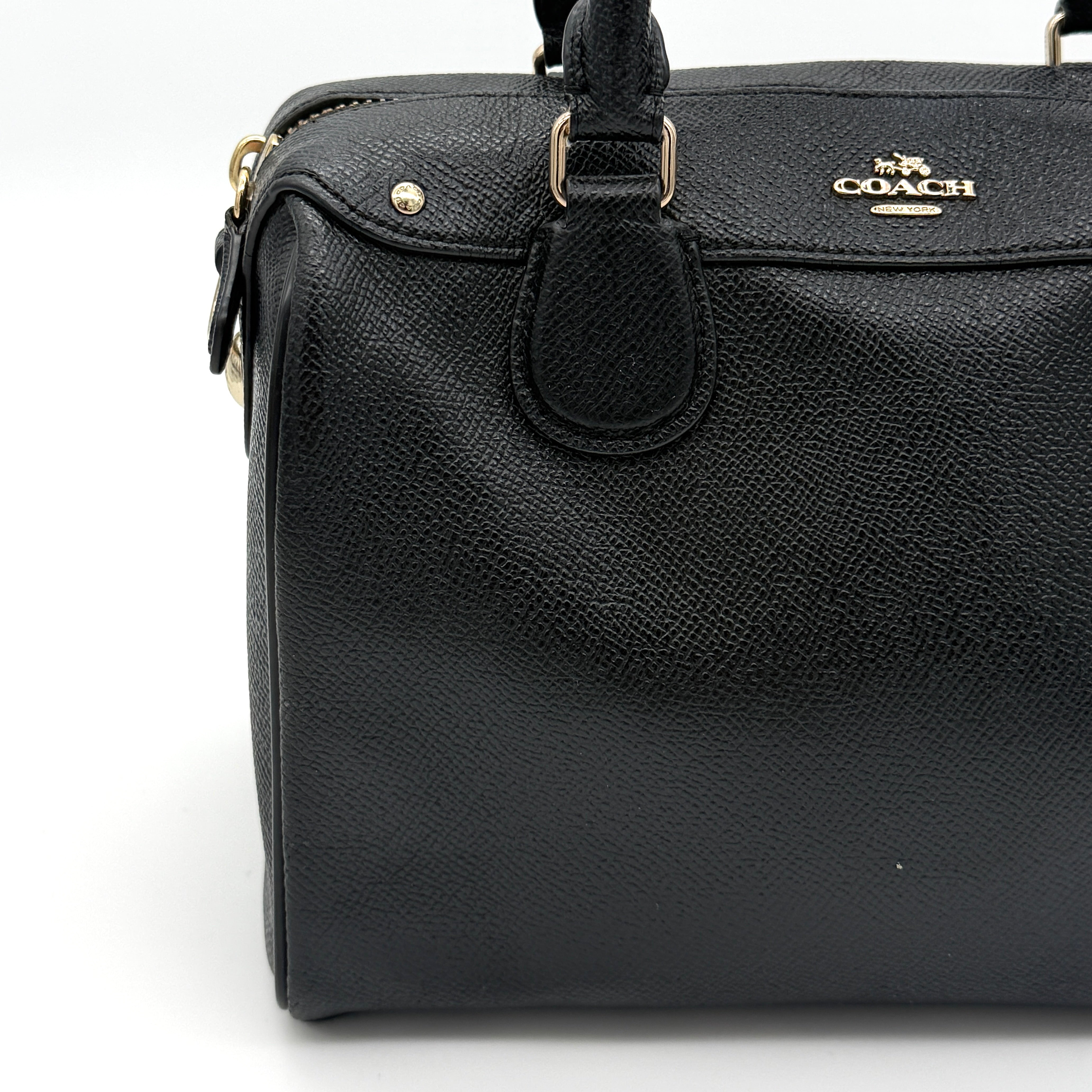 Front-facing image of the Coach Mini Bennett Boston Bag in black grained leather with gold hardware.